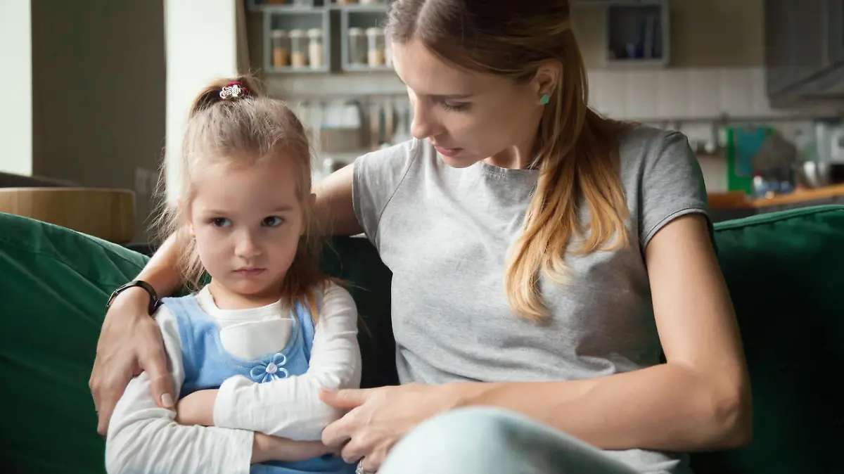 Loving mother consoling or trying make peace with insulted upset stubborn kid daughter avoiding talk, sad sulky resentful girl pouting ignoring caring mom embracing showing support to offended child