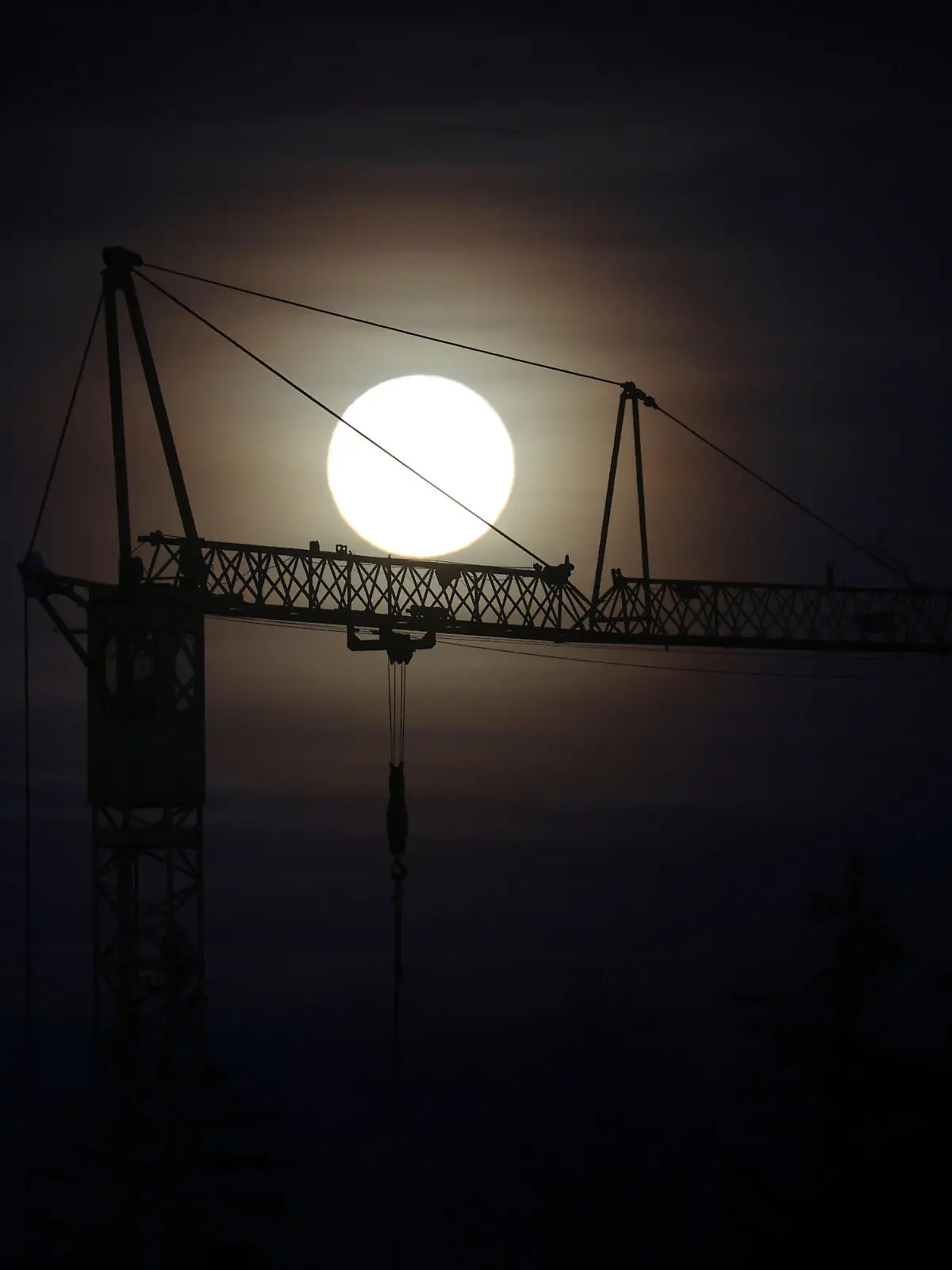08.11.2022, Bayern, Steingaden: Der Vollmond steht hinter dem Ausleger eines Baukrans am Himmel. Foto: Karl-Josef Hildenbrand/dpa +++ dpa-Bildfunk +++