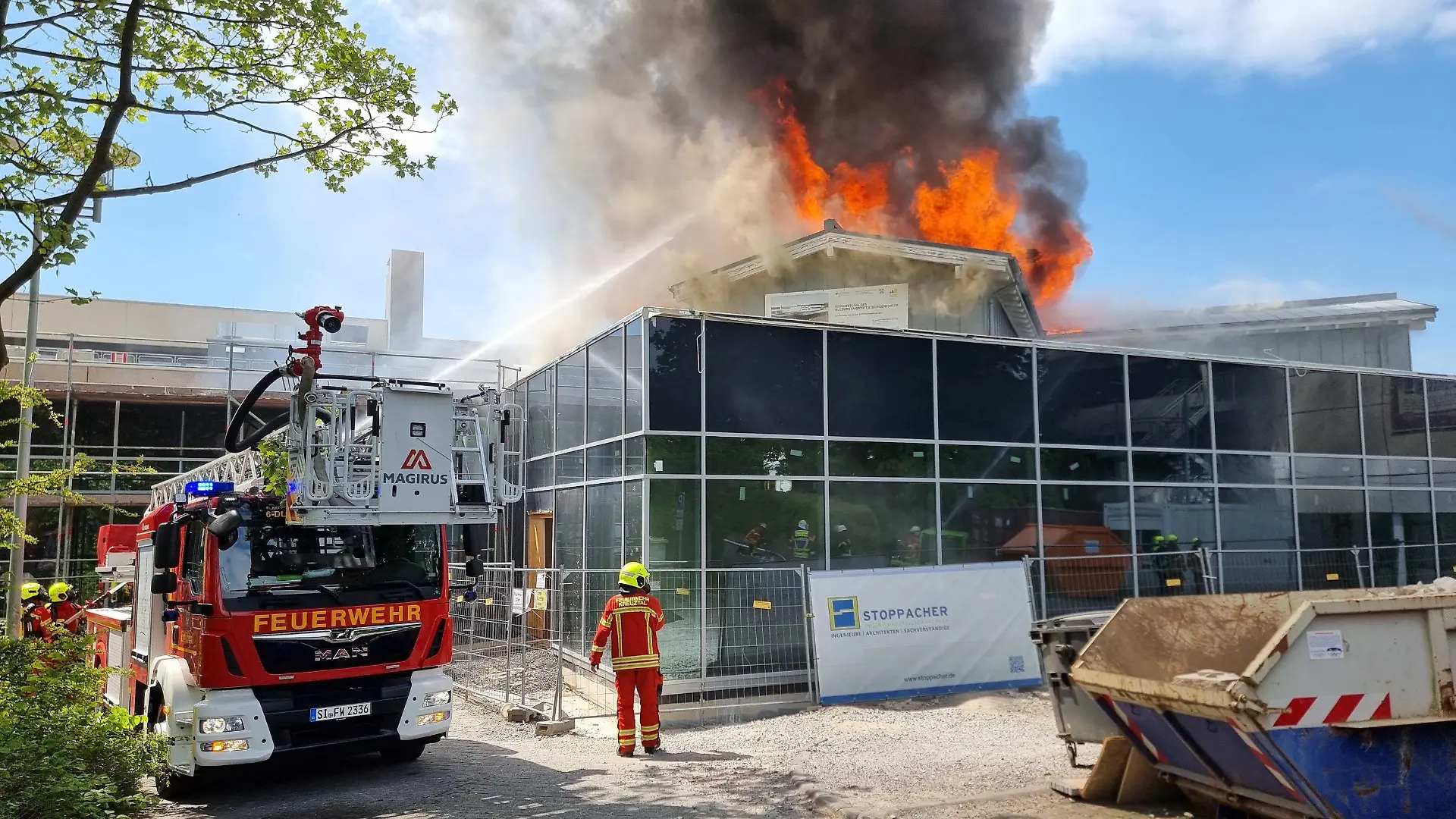 16.05.2022, Nordrhein-Westfalen, Kreuztal: Einsatzkräfte der Feuerwehr löschen die Flammen. Die Stadthalle in Kreuztal im Siegerland ist am Montag niedergebrannt. Foto: Kai Osthoff/dpa +++ dpa-Bildfunk +++