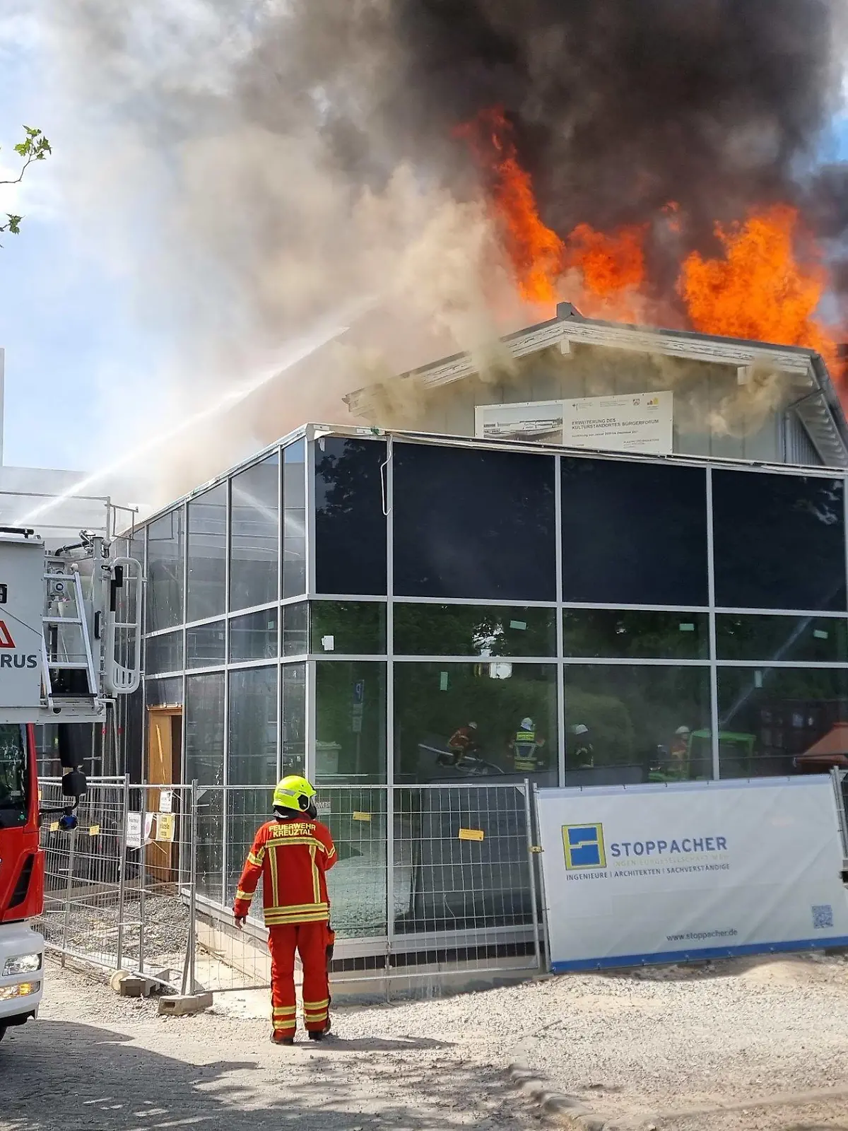 16.05.2022, Nordrhein-Westfalen, Kreuztal: Einsatzkräfte der Feuerwehr löschen die Flammen. Die Stadthalle in Kreuztal im Siegerland ist am Montag niedergebrannt. Foto: Kai Osthoff/dpa +++ dpa-Bildfunk +++
