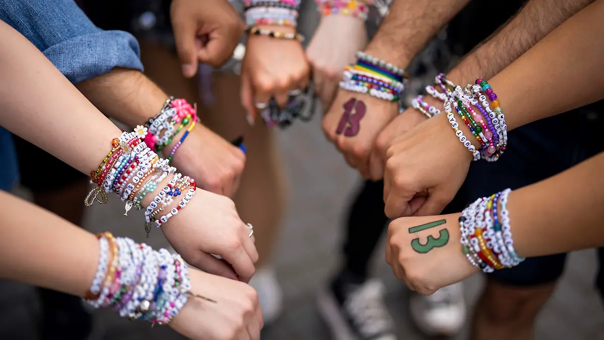 Swifties zeigen ihre selbstgebastelten friendship bracelets, die ebenfalls zur Tour und zum „Eras”-Style gehören.