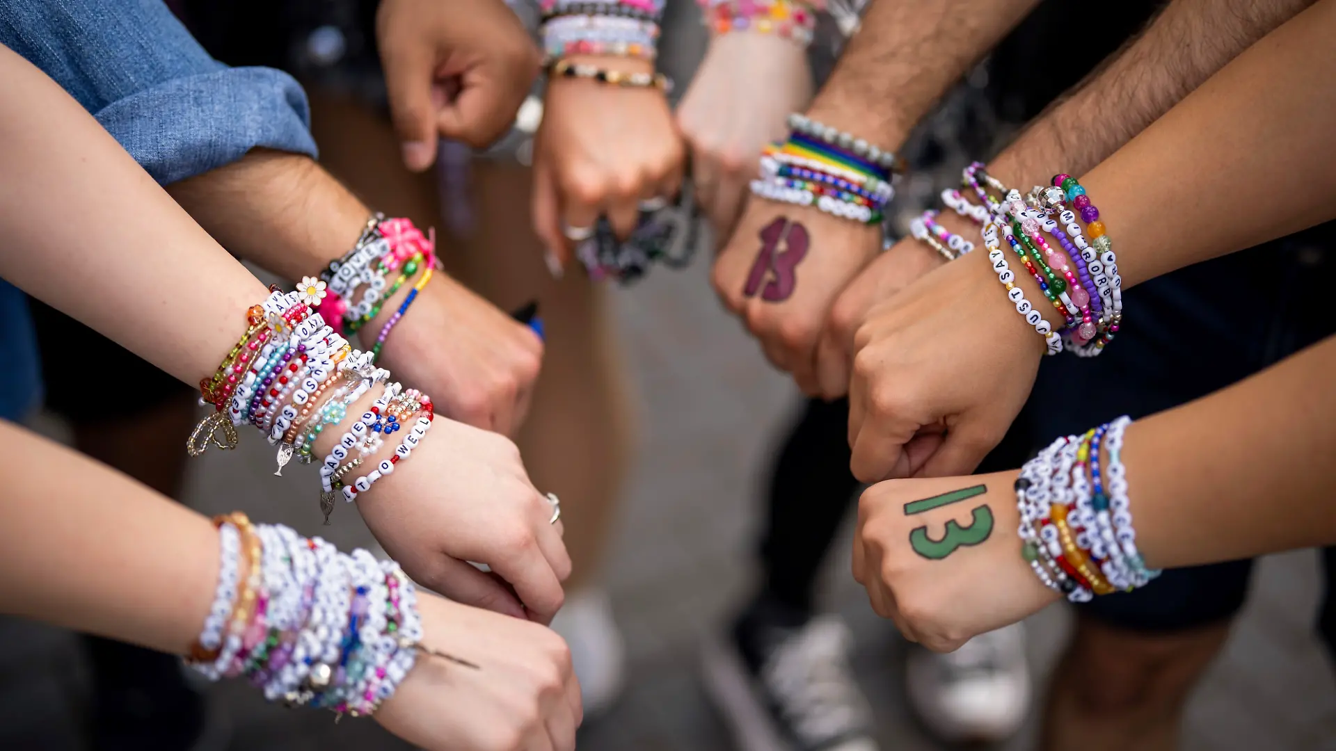 Swifties zeigen ihre selbstgebastelten friendship bracelets, die ebenfalls zur Tour und zum „Eras”-Style gehören.