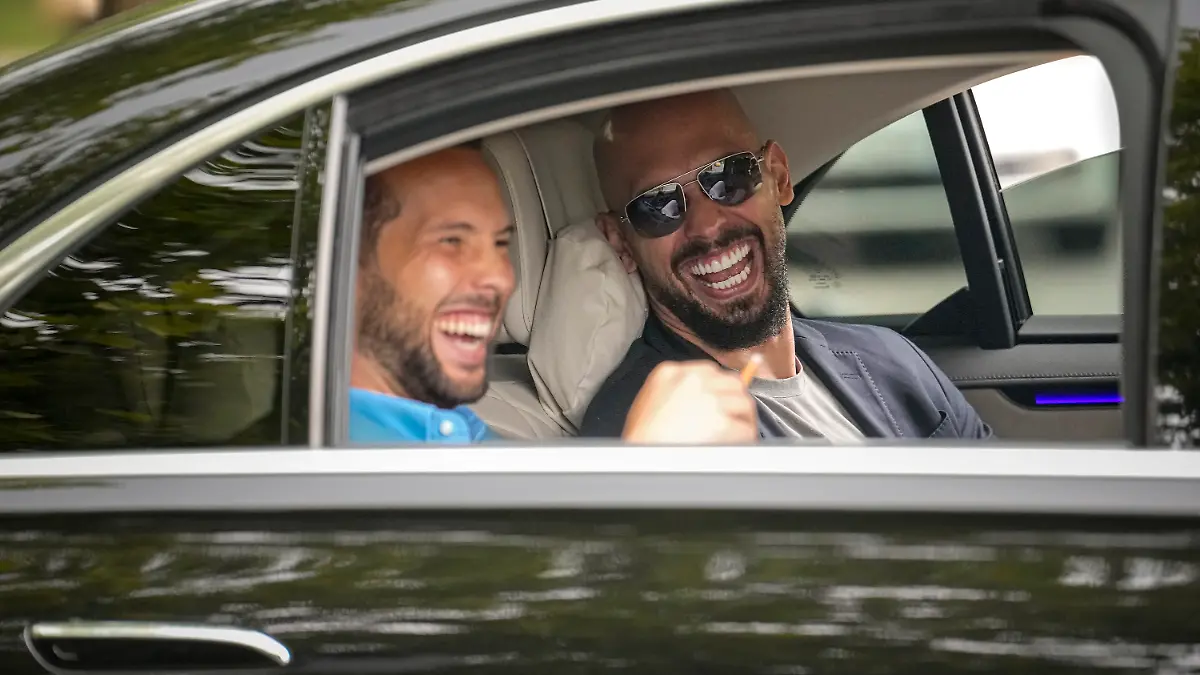 FILE - Andrew Tate, right, and his brother Tristan laugh as they leave the Bucharest Tribunal in Bucharest, Romania, Wednesday, May 8, 2024. A court in Romania’s capital on Friday, July 5, 2024 ruled that the online influencer Andrew Tate can leave Romanian territory providing he remains within the European Union, as he awaits trial on charges of human trafficking, rape and forming a criminal gang to sexually exploit women. (AP Photo/Vadim Ghirda, File)