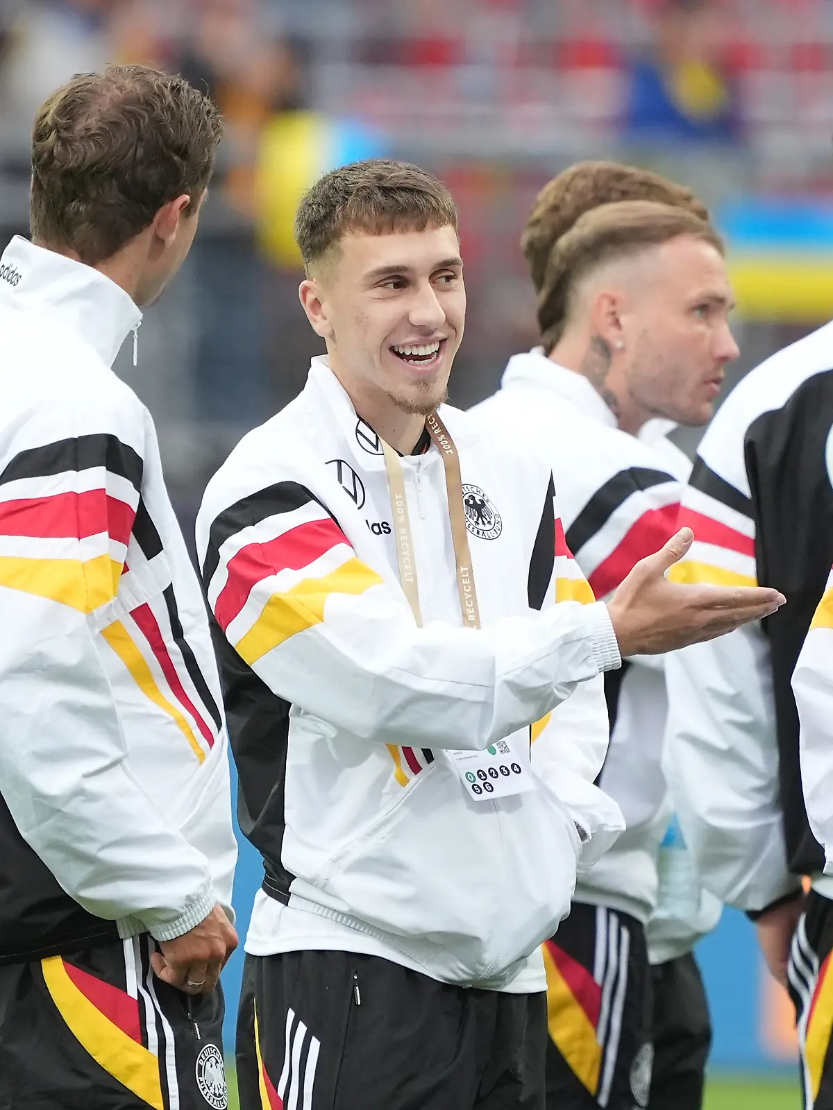 Brajan Gruda und Aleksandar Pavlovic mit mit Thomas Müller im Trainingsanzug der deutschen Nationalmannschaft