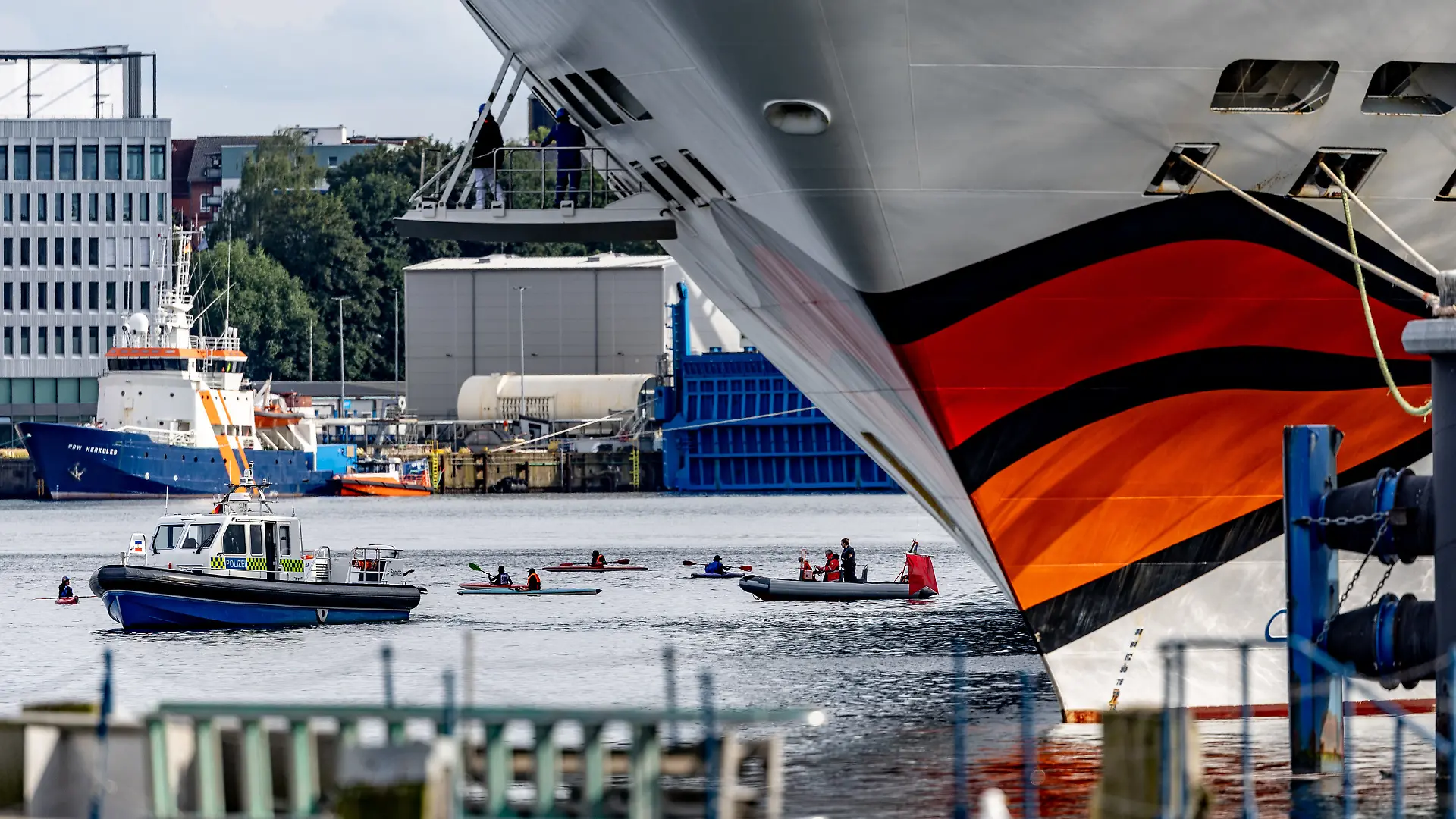 Gegner des Kreuzfahrttourismus versuchen mit Kajaks Kreuzfahrtschiffe in Kiel am Auslaufen zu hindern.