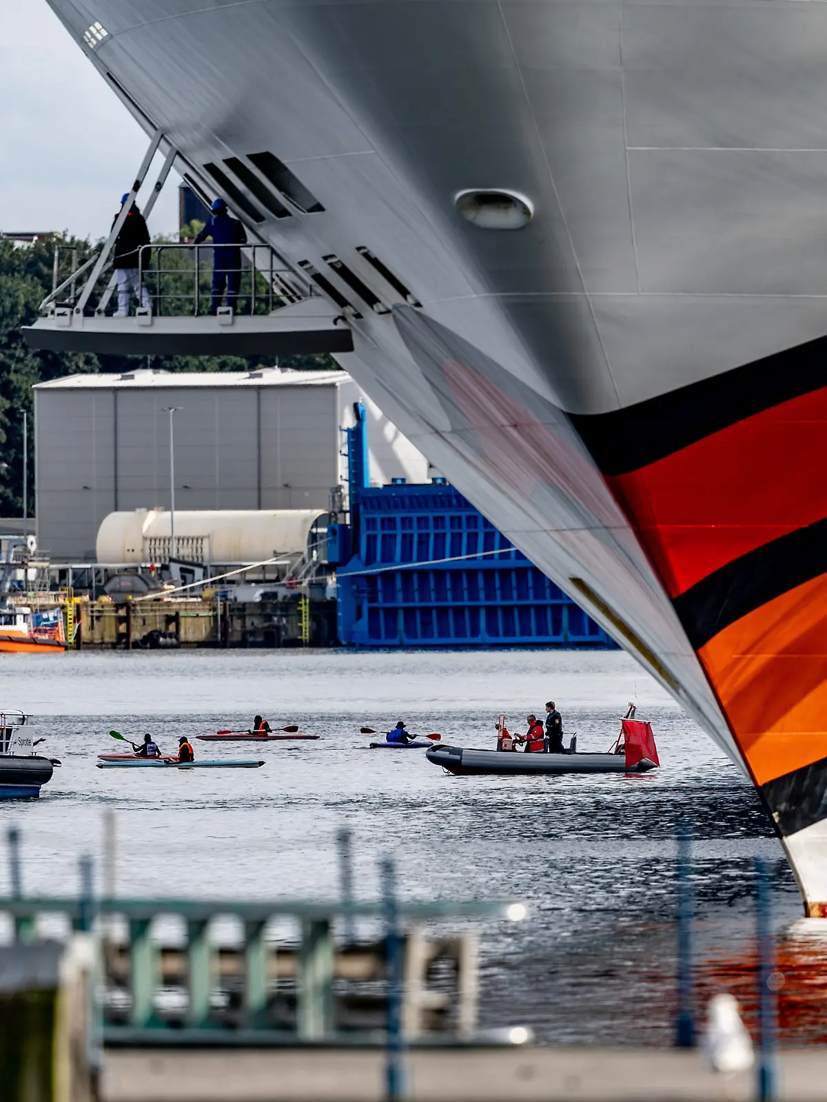 Gegner des Kreuzfahrttourismus versuchen mit Kajaks Kreuzfahrtschiffe in Kiel am Auslaufen zu hindern. 