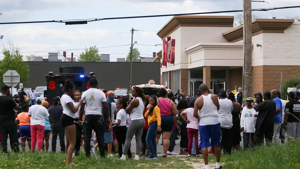 14.05.2022, USA, Buffalo: Eine Menschenmenge versammelt sich, während die Polizei nach Schüssen in einem Supermarkt ermittelt. Nach Schüssen in der US-Stadt Buffalo sind übereinstimmenden Medienberichten zufolge mindestens acht Menschen gestorben. Foto: Joshua Bessex/FR171816 AP/dpa +++ dpa-Bildfunk +++