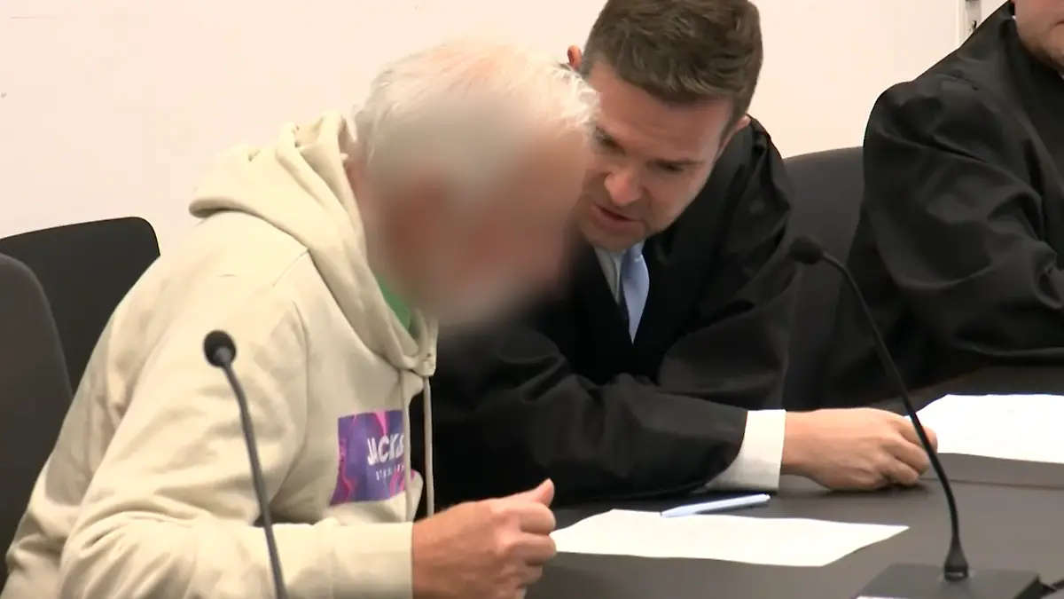 Ein Mann auf einer Anklagebank vor Gericht. 