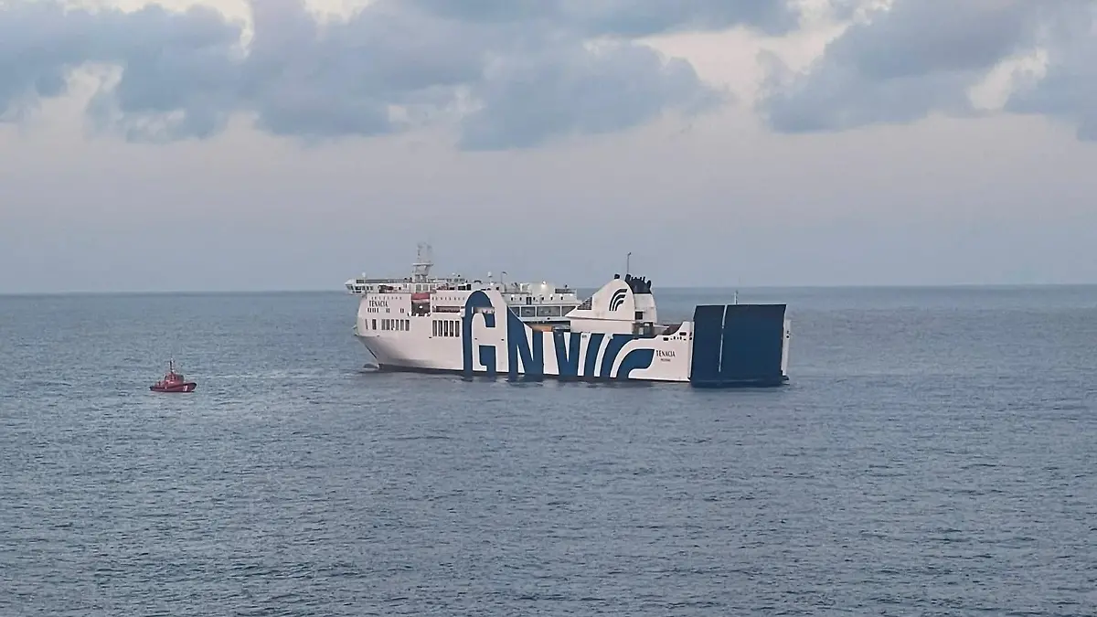 Eine Tenacia-Fähre und ein kleines Feuerwehrboot auf hoher See. 