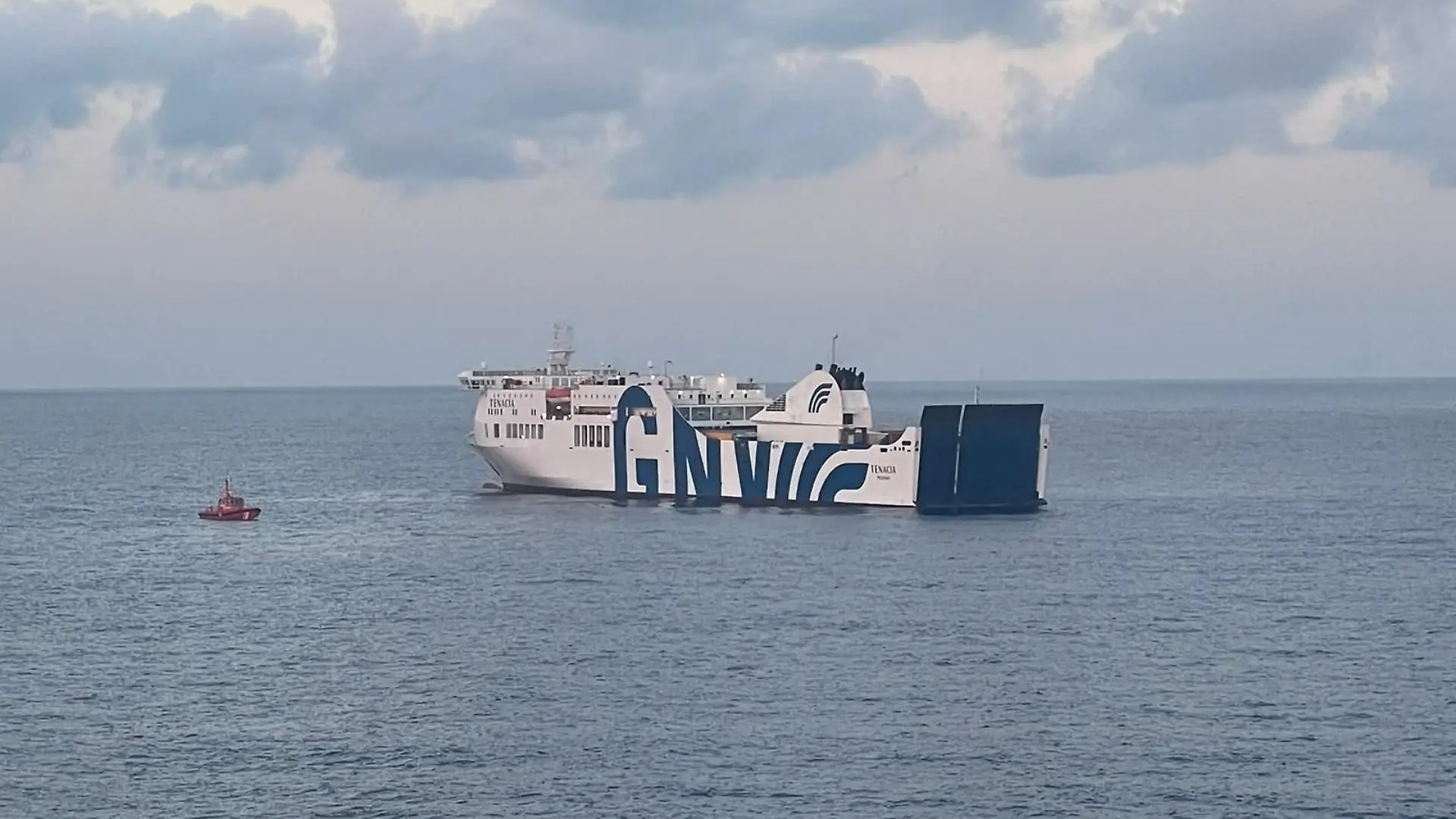 Eine Tenacia-Fähre und ein kleines Feuerwehrboot auf hoher See.
