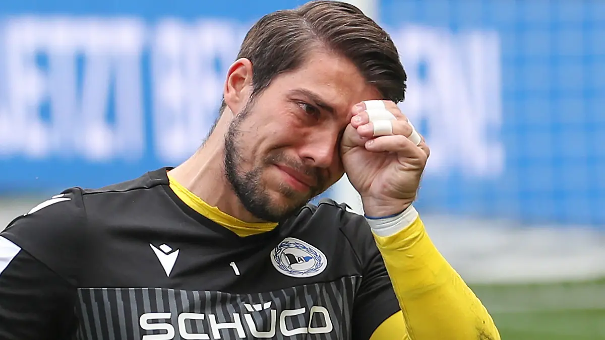 14.05.2022, Nordrhein-Westfalen, Bielefeld: Fußball: Bundesliga, Arminia Bielefeld - RB Leipzig, 34. Spieltag in der Schüco-Arena. Bielefelds Torwart Stefan Ortega weint bei seiner Verabschiedung. Foto: Friso Gentsch/dpa - WICHTIGER HINWEIS: Gemäß den Vorgaben der DFL Deutsche Fußball Liga bzw. des DFB Deutscher Fußball-Bund ist es untersagt, in dem Stadion und/oder vom Spiel angefertigte Fotoaufnahmen in Form von Sequenzbildern und/oder videoähnlichen Fotostrecken zu verwerten bzw. verwerten zu lassen. +++ dpa-Bildfunk +++