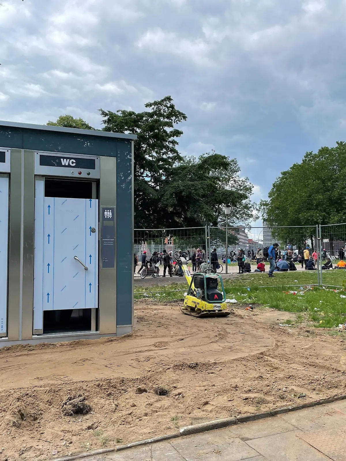Die neuen Toiletten sind schon da. Im Hitergund sieht man, wie viele Menschen sich hier vor dem Drop Inn aufhalten.