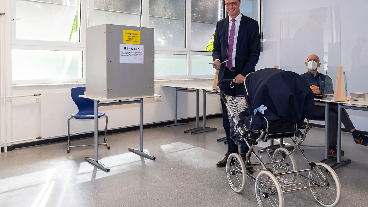 dpatopbilder - 15.05.2022, Nordrhein-Westfalen, Rhede: Hendrik Wüst (CDU), Ministerpräsident des Landes Nordrhein-Westfalen, steht zusammen mit dem Kinderwagen seiner Tochter Philippa im Wahllokal und gibt seinen Stimmzettel ab. In Nordrhein-Westfalen findet am Sonntag die Wahl zum 18. Landtag statt. Rund 13,2 Millionen Menschen sind zur Wahl aufgerufen. Foto: Guido Kirchner/dpa +++ dpa-Bildfunk +++