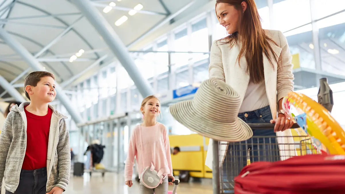 Mutter und zwei Kinder im Flughafen Terminal machen eine Urlaubsreise mit dem Flugzeug 