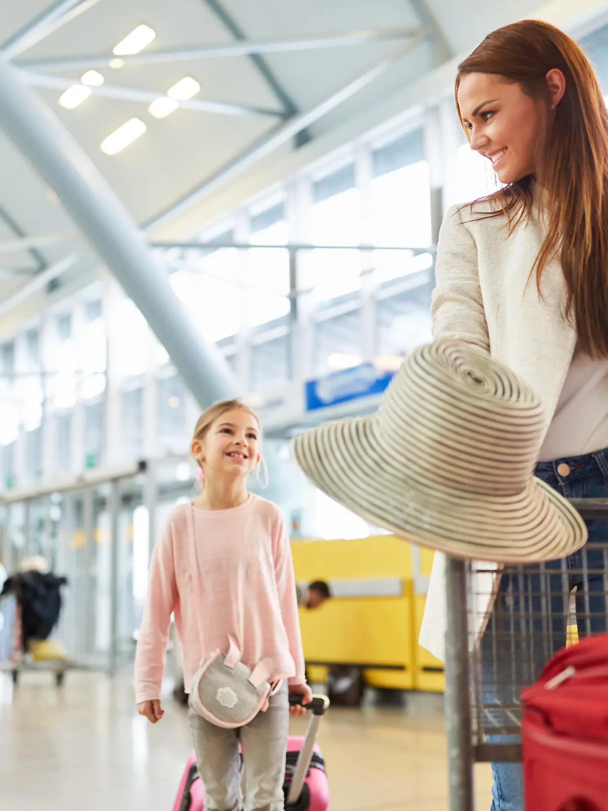 Mutter und zwei Kinder im Flughafen Terminal machen eine Urlaubsreise mit dem Flugzeug 