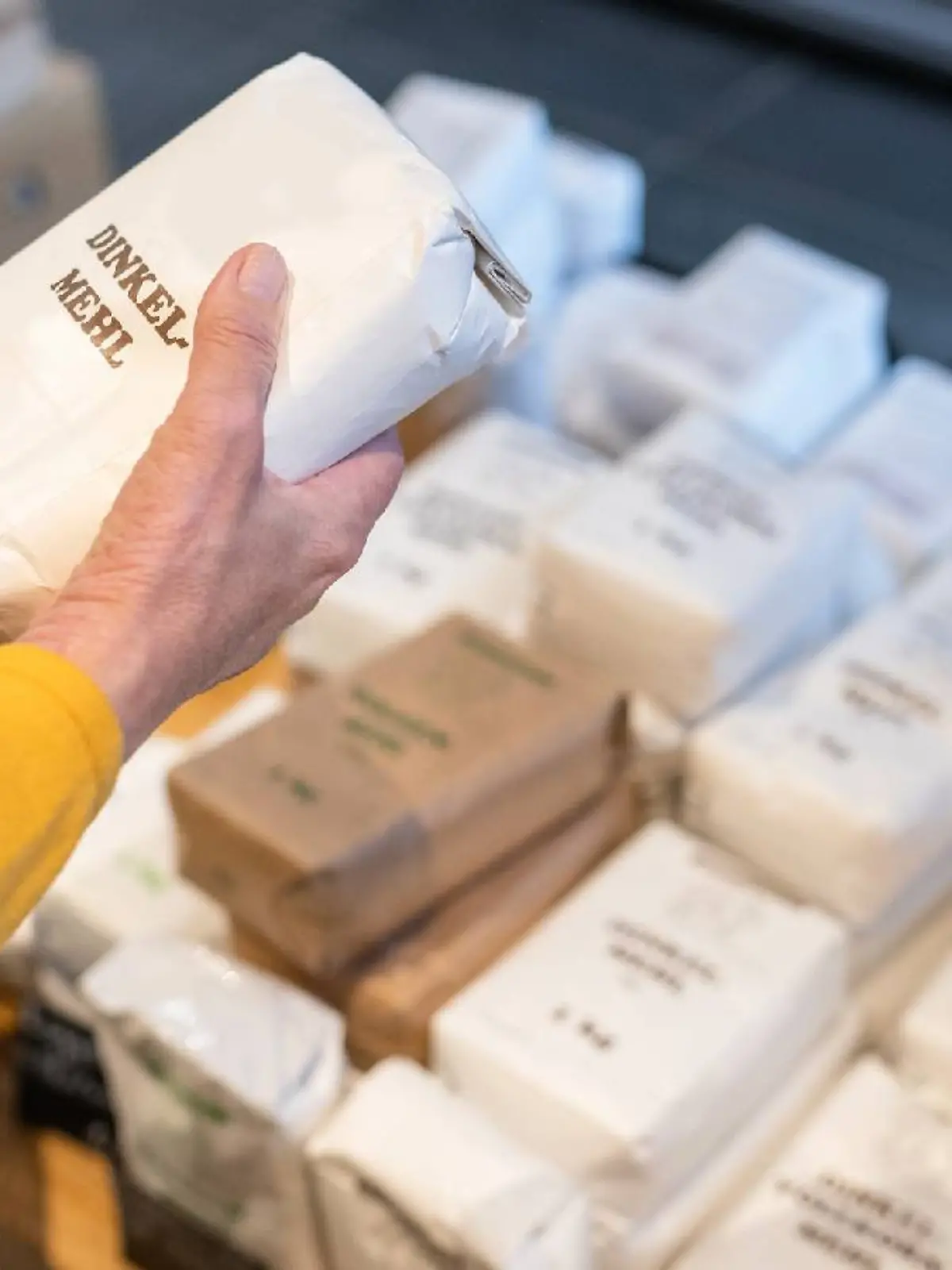 Eine Frau hält eine Packung Mehl in der Hand.