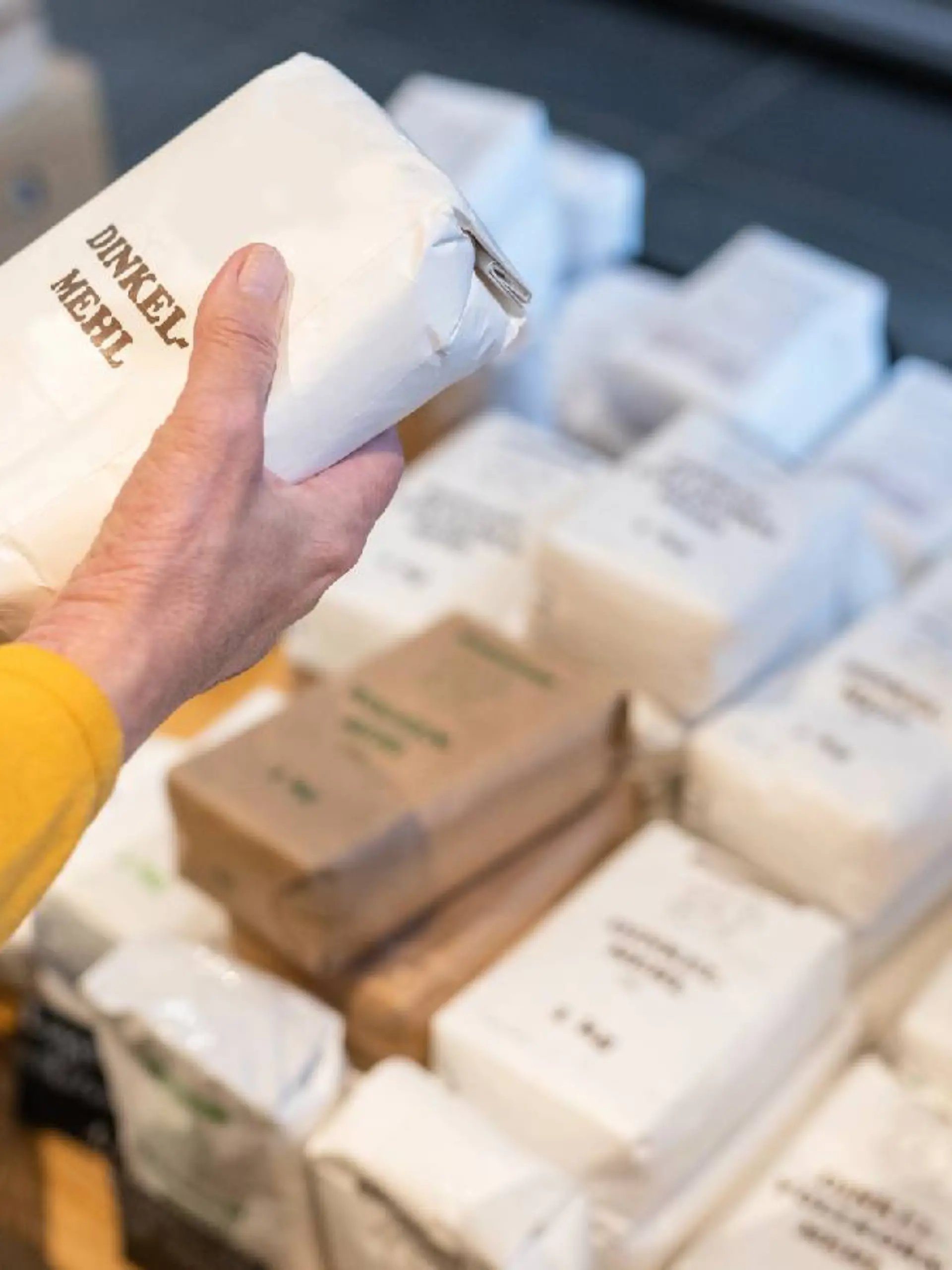 Eine Frau hält eine Packung Mehl in der Hand.