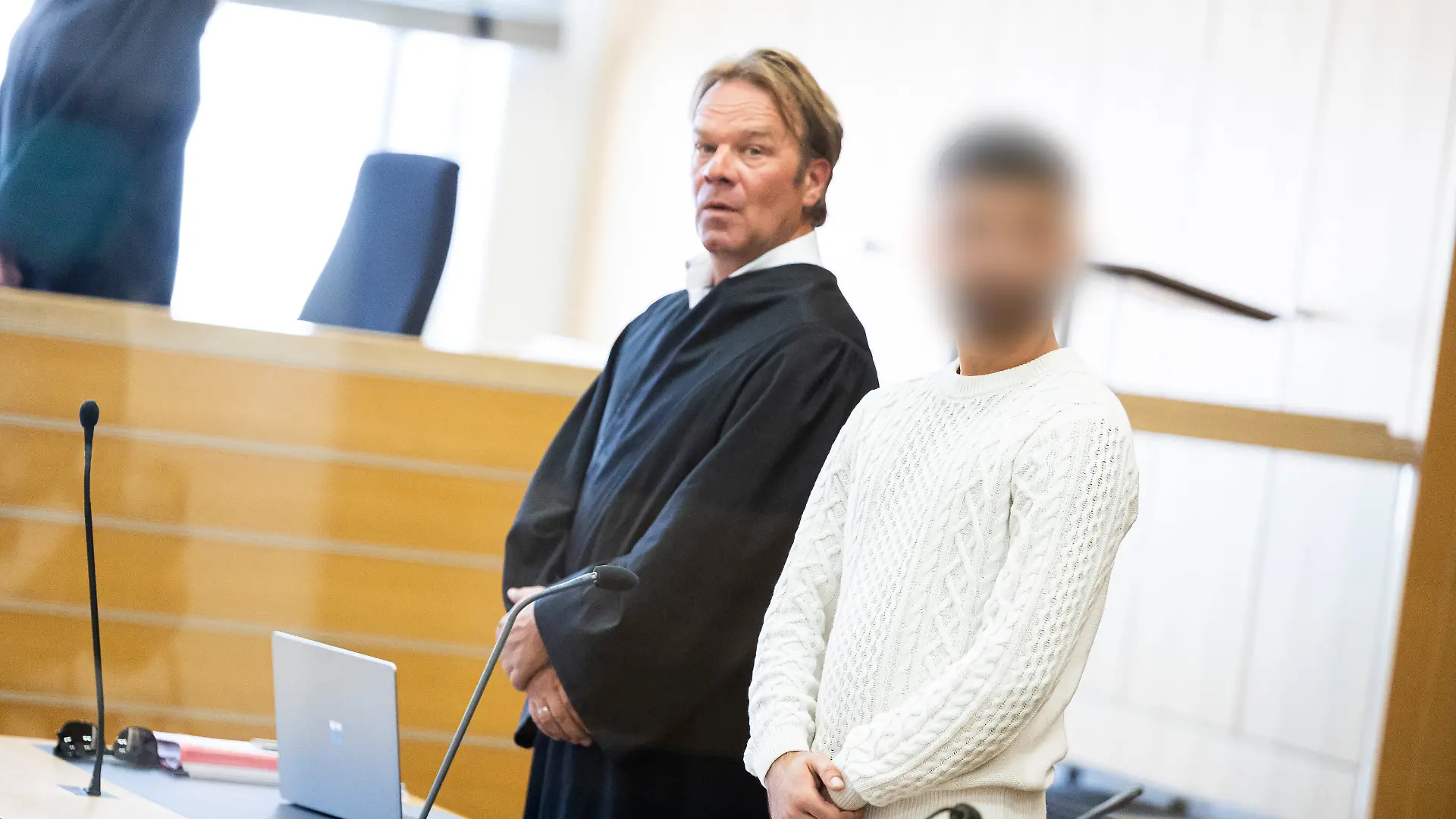 Der Angeklagte (r) steht vor Verhandlungsbeginn in einen Gerichtssaal im Landgericht Braunschweig neben seinem Anwalt Martin Voß (l). Der 25-jährige Angeklagte soll mit seiner Schwester beschlossen haben, den mutmaßlich gewaltsamen Tod des gemeinsamen Vaters im Jahr 2022 zu rächen. Dazu soll die Schwester im Mai 2023 das Opfer in der Schweiz ausfindig gemacht und unter einer anderen Identität eine Liebesbeziehung zu dem Opfer aufgebaut haben. Dort lockte der Angeklagte den Mann am 13.06.2023 in eine Falle und verletzte ihn tödlich mit einem Messer.
