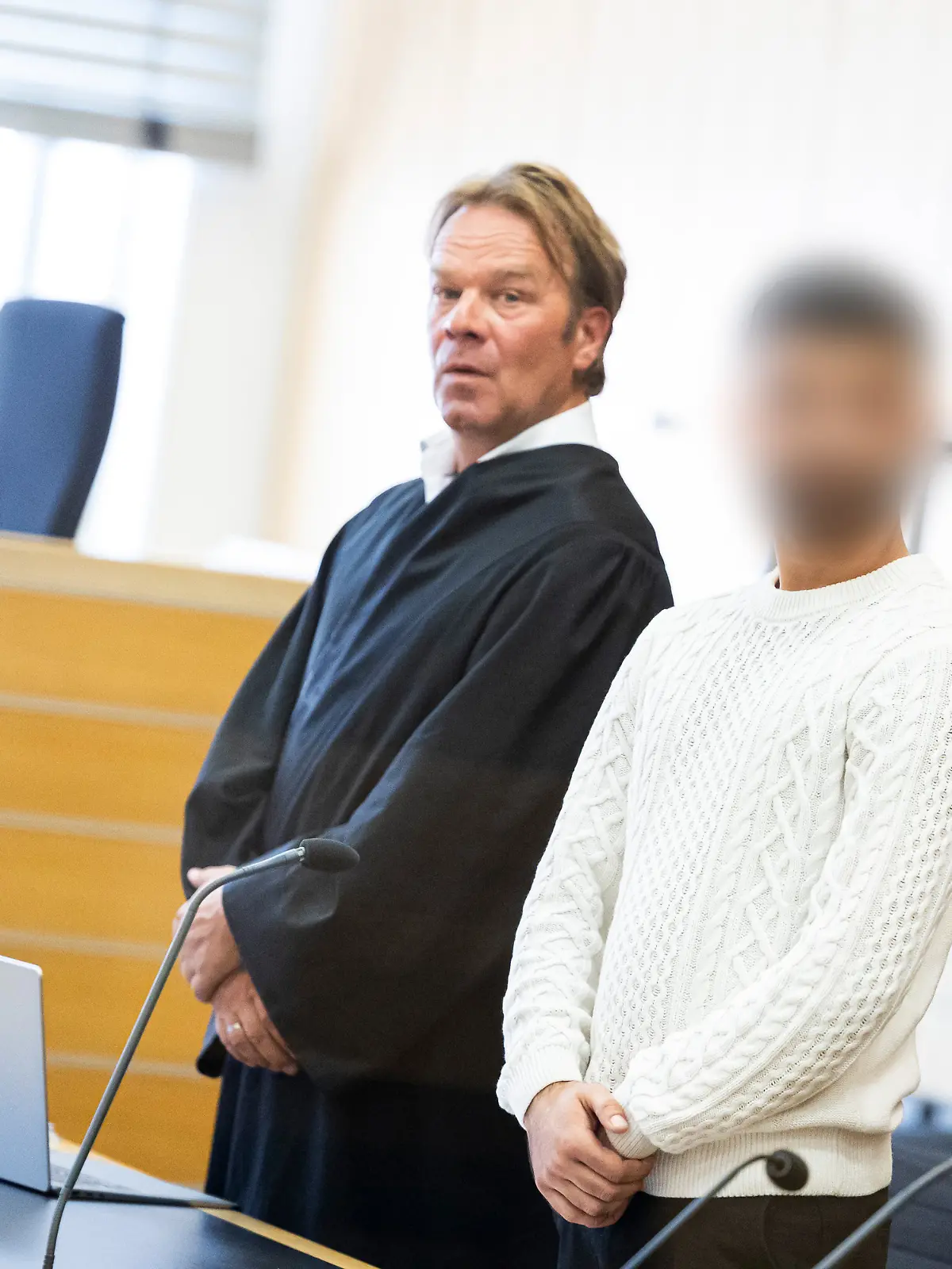Der Angeklagte (r) steht vor Verhandlungsbeginn in einen Gerichtssaal im Landgericht Braunschweig neben seinem Anwalt Martin Voß (l). Der 25-jährige Angeklagte soll mit seiner Schwester beschlossen haben, den mutmaßlich gewaltsamen Tod des gemeinsamen Vaters im Jahr 2022 zu rächen. Dazu soll die Schwester im Mai 2023 das Opfer in der Schweiz ausfindig gemacht und unter einer anderen Identität eine Liebesbeziehung zu dem Opfer aufgebaut haben. Dort lockte der Angeklagte den Mann am 13.06.2023 in eine Falle und verletzte ihn tödlich mit einem Messer.