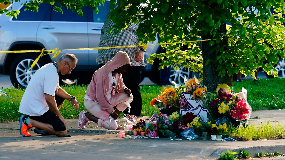 15.05.2022, USA, Buffalo: Menschen knien vor Blumen, um den Opfern tödlicher Schüsse in einem Supermarkt in Buffalo die letzte Ehre zu erweisen. Ein Schütze hatte am Samstag (14.05.2022) in der Stadt Buffalo im Bundesstaat New York das Feuer eröffnet und mindestens zehn Menschen getötet. Die demokratische Vorsitzende des US-Repräsentantenhauses Pelosi hat die Schüsse in der Stadt Buffalo als «Inlandsterrorismus» bezeichnet. Foto: Matt Rourke/AP/dpa +++ dpa-Bildfunk +++