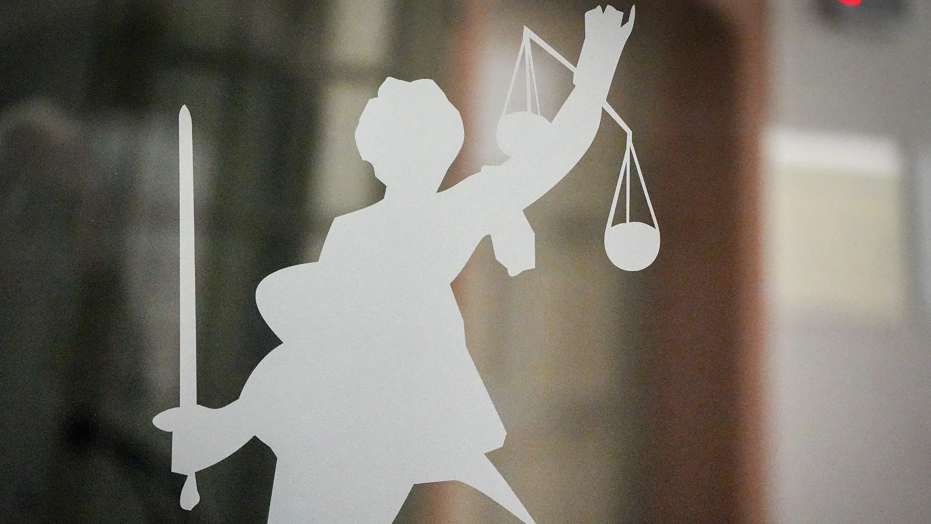 ARCHIV - 27.04.2023, Berlin: Die Figur der Justitia mit Richtschwert und Waage ist auf dem Glasfenster einer Tür im Gerichtsgebäude zu sehen. Nach dem Willen der EU-Staaten sollen Journalisten und Menschenrechtsaktivisten stärker gegen ungerechtfertigte Klagen geschützt werden. Foto: Soeren Stache/dpa +++ dpa-Bildfunk +++