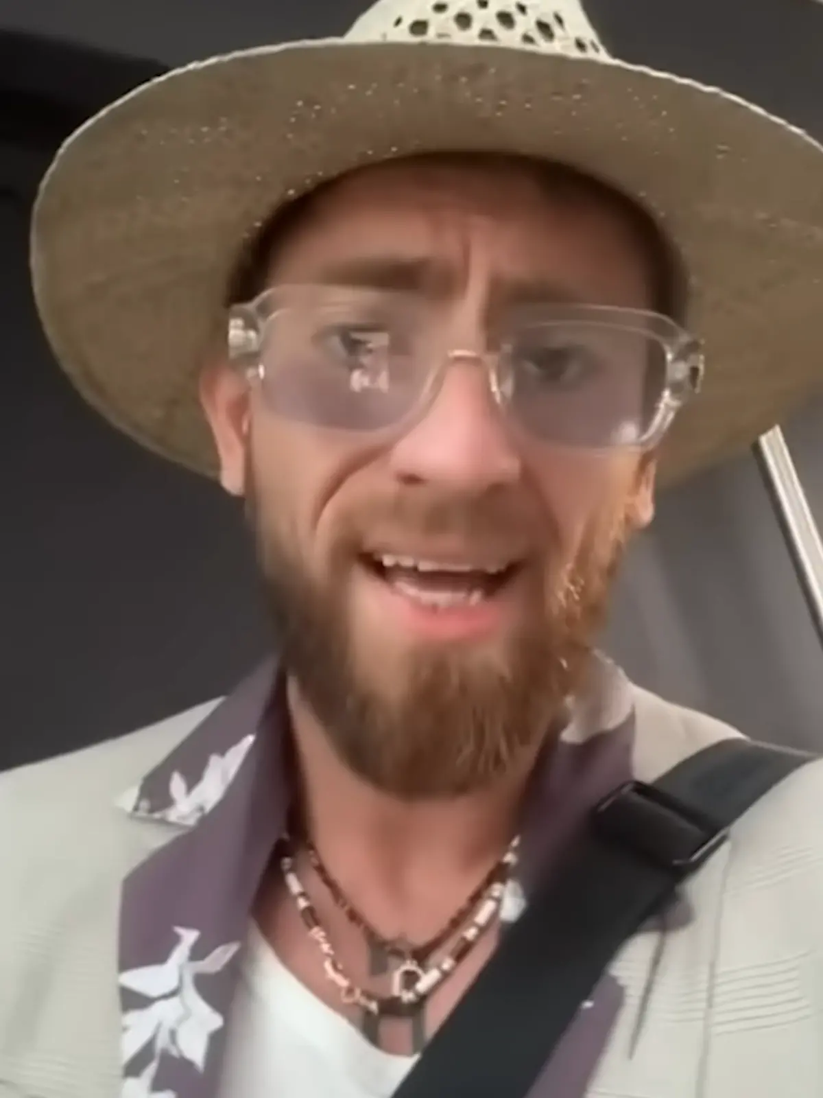 Ein Mann mit Hut und Brille blickt in die Kamera. 