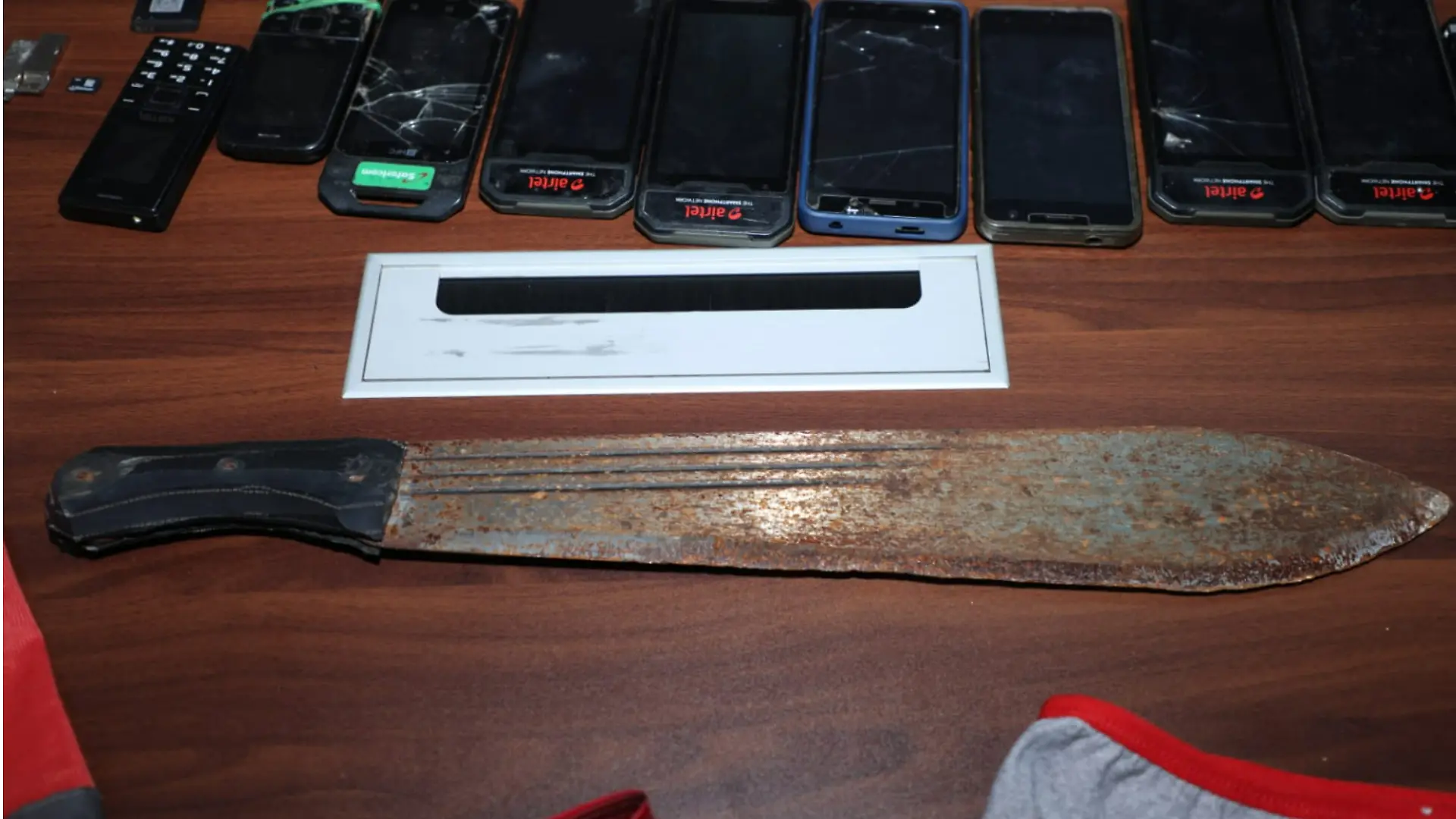 Eine rostige Machete liegt auf einem Tisch.