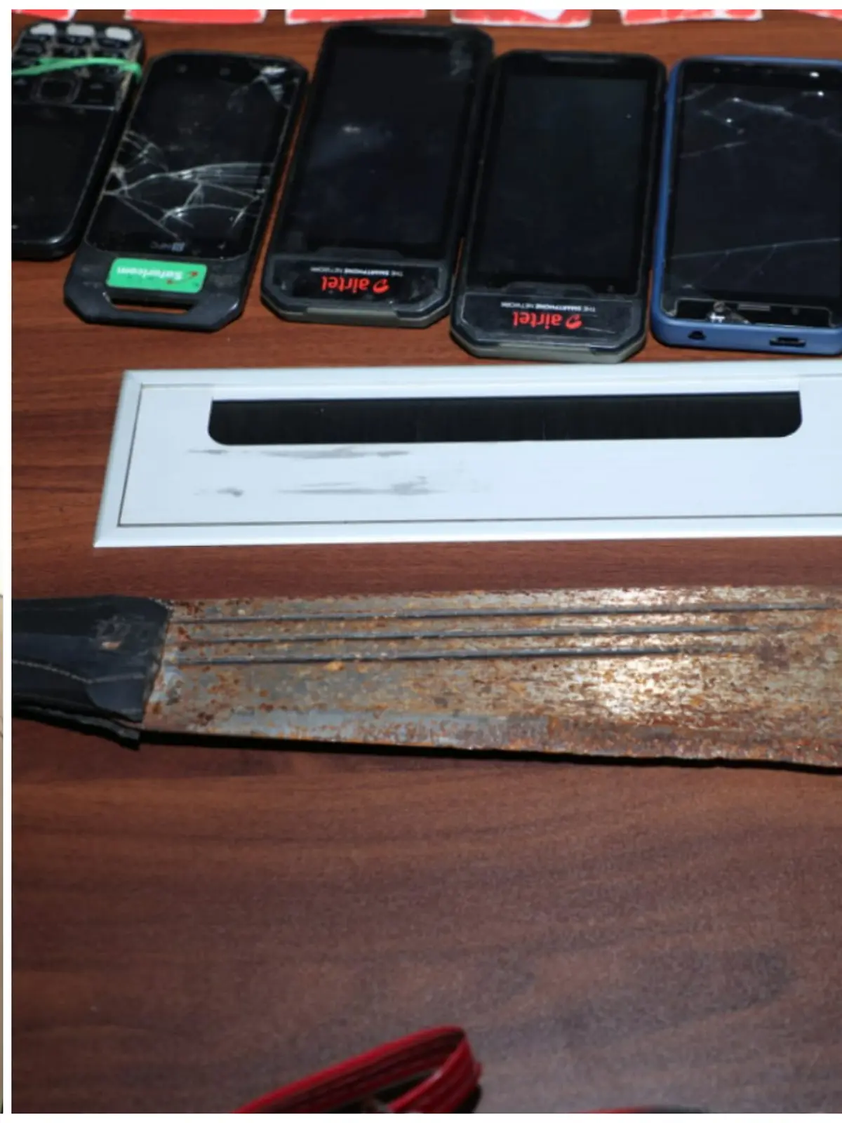 Ein Mann auf einem Polizeifoto, daneben eine rostige Machete auf einem Tisch. 