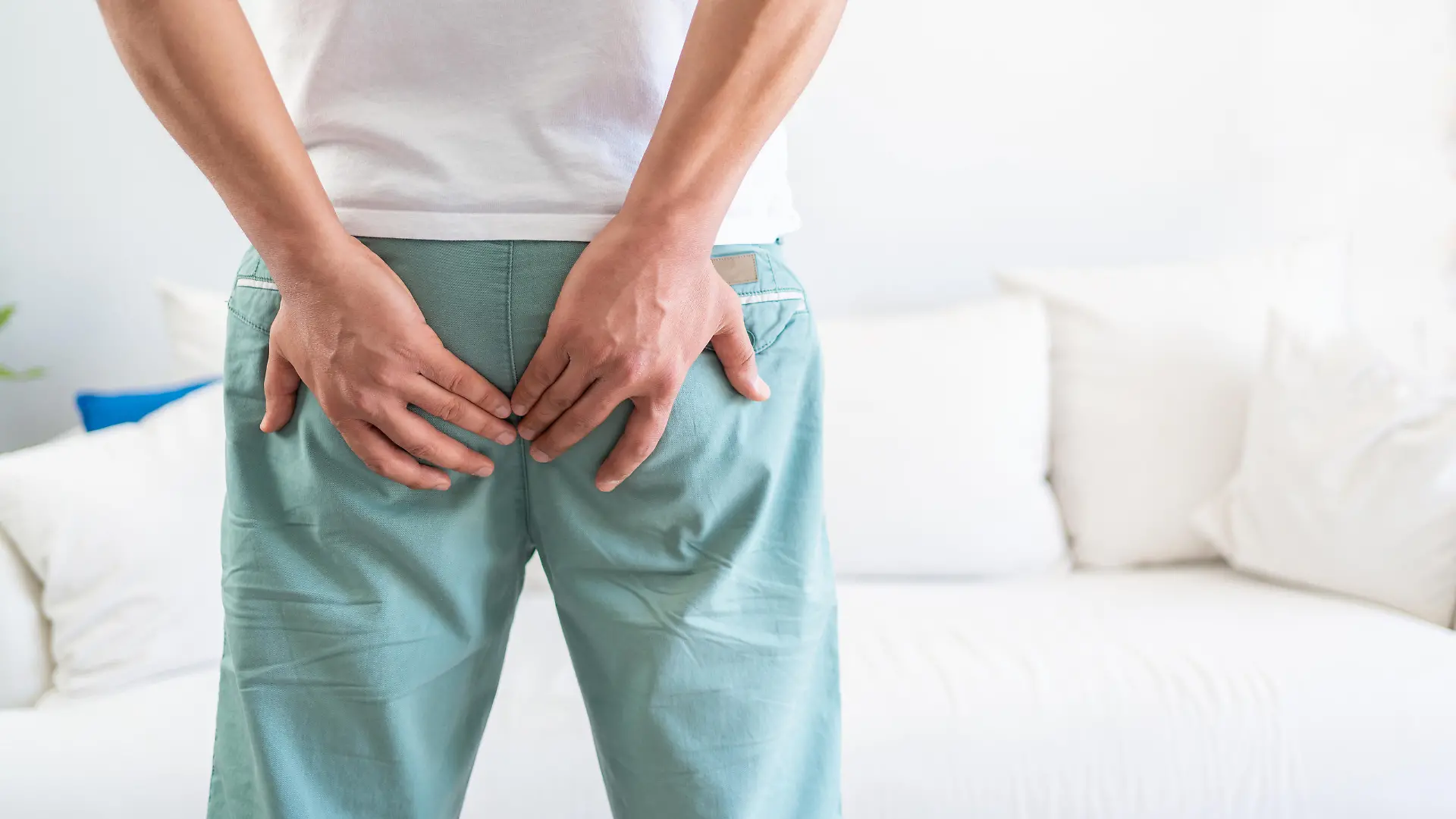 Man suffer from hemorrhoids. Man hand holding his bottom because hemorrhoids. Man with hemorrhoids and constipation. The pain caused by hemorrhoid