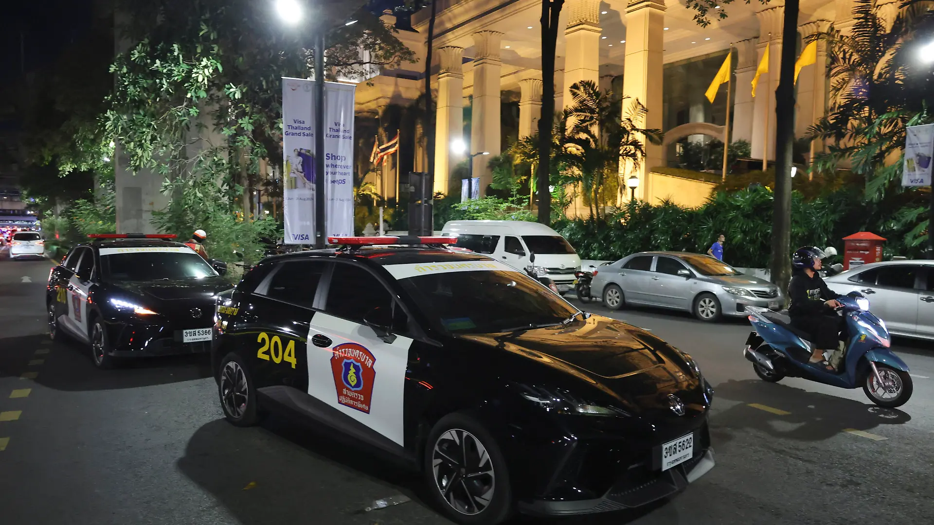 Police cars are parked outside the Grand Hyatt Erawan Hotel in Bangkok, Thailand, Tuesday, July 16, 2024. Police said a number of people were found dead Tuesday in the luxury hotel in downtown B