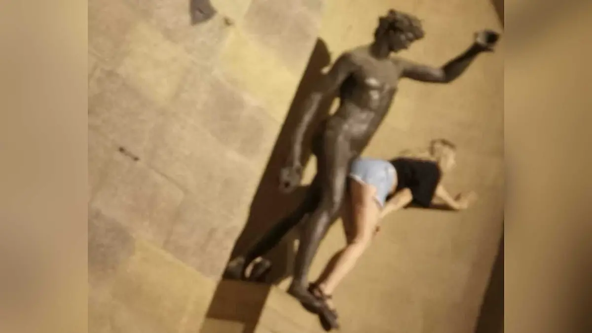 Diese Frau posiert anzüglich mit einer Statue und lässt sich dabei fotografieren.