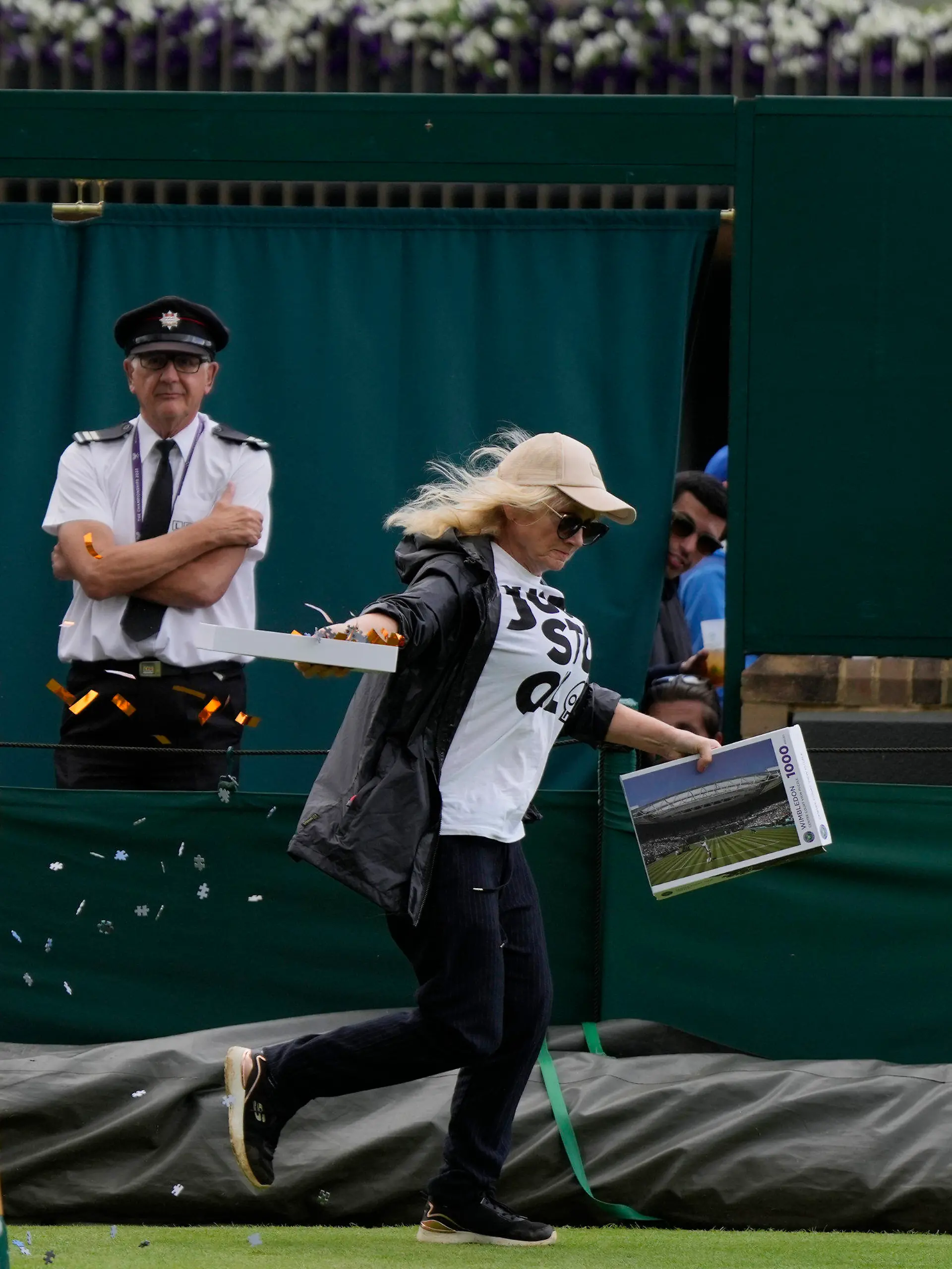A Just Stop Oil protester runs onto Court 18 and releases confetti on day three of the Wimbledon tennis championships in London, Wednesday, July 5, 2023. (AP Photo/Alastair Grant)