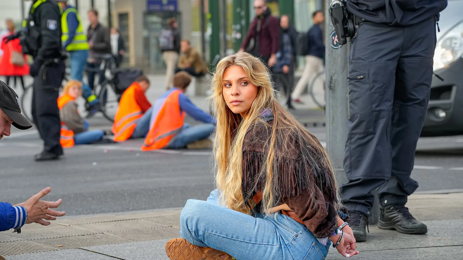 Berlin, Die Aktivisten der Gruppe Letzte Generation bei einer Blockade-Aktion im Bereich Ecke Potsdamer Platz / Ebertstraße / Leipziger Platz im Bezirk Mitte. Im Bild: Die Klimaaktivistin Anja Windl, alias Klima-Shakira in Handschellen. Sie gehoert zu den bekannten Gesichtern der Klimabewegung Letzte Generation in Oesterreich.