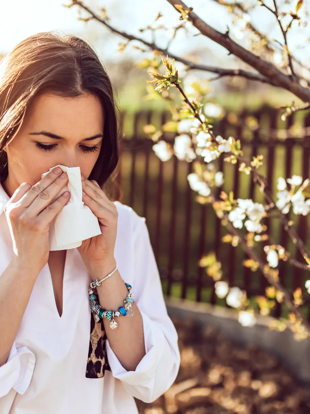 Attractive young adult woman coughing and sneezing outdoors. Sick people allergy or virus influenca concept.