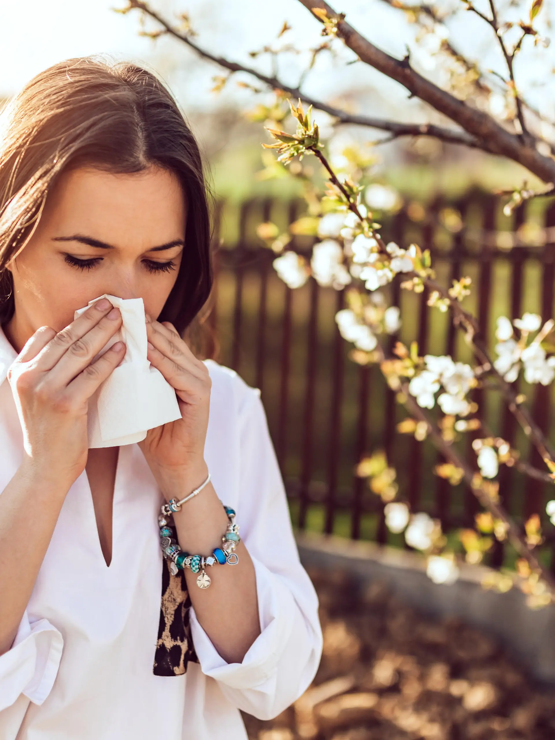 Attractive young adult woman coughing and sneezing outdoors. Sick people allergy or virus influenca concept.