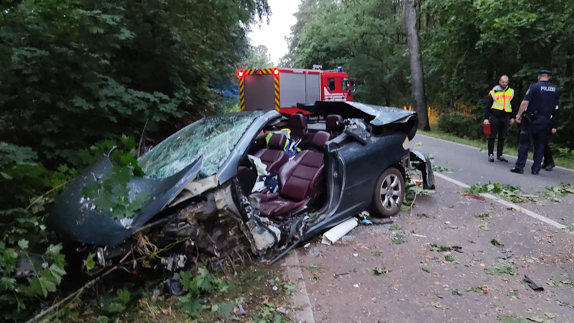 Rettungskräfte sind an einer Unfallstelle bei Schönberg. Ein 44-jähriger Mann ist mit seinem Auto bei Schönberg (Landkreis Ostprignitz-Ruppin) nahe Neuruppin gegen einen Baum geprallt und tödlich verletzt worden. Wie die Polizei am Montag mitteilte, kam der Mann in der Nacht auf Montag in der Nähe des Abzweigs nach Wulkow in einer Rechtskurve von der Straße ab und prallte mit dem Auto gegen einen Baum.