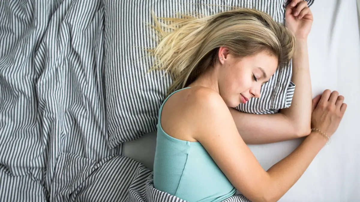 Frau schläft im Bett.