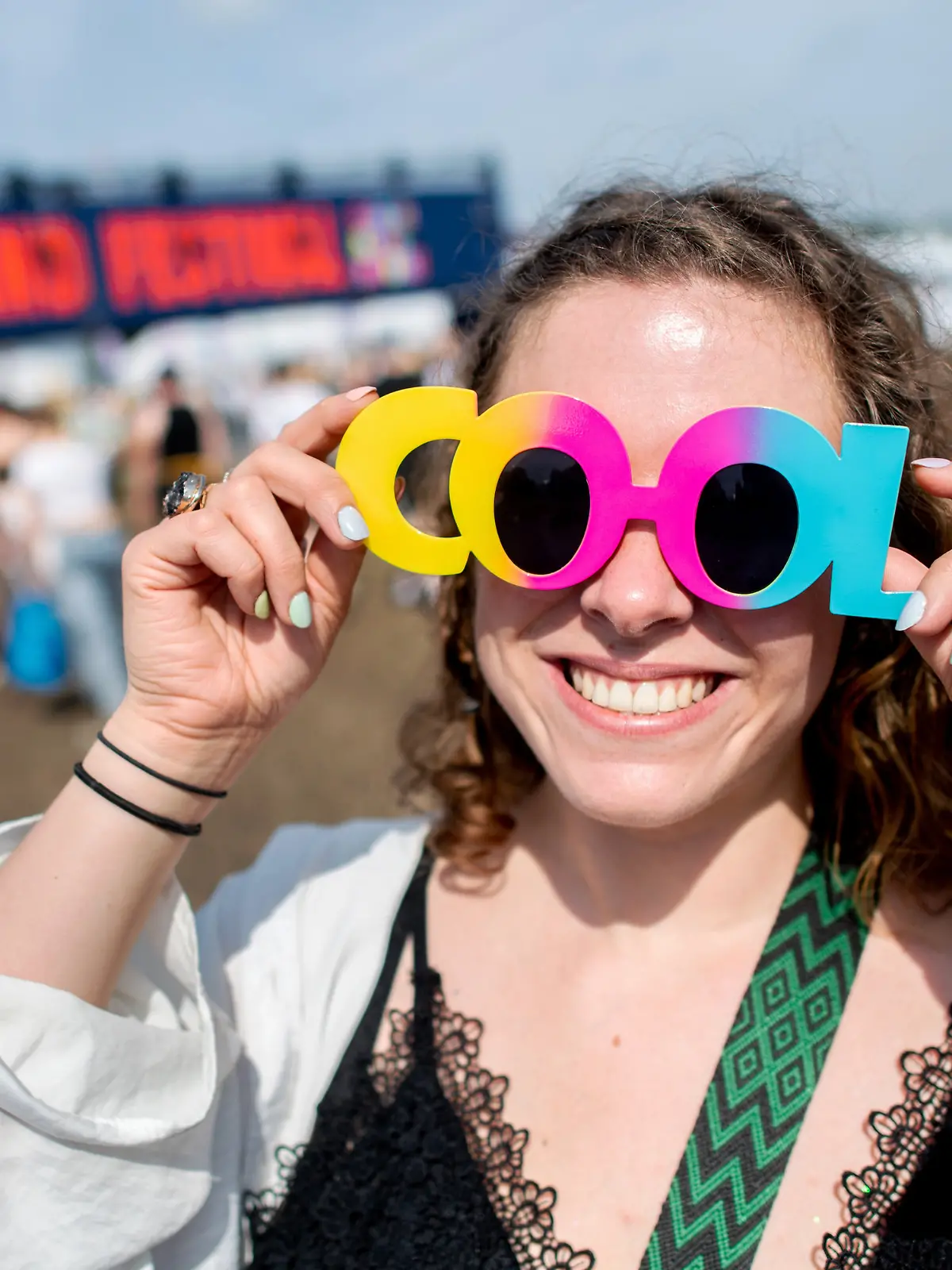 18.07.2024, Niedersachsen, Nordholz: Festivalbesucherin Lynn steht mit einer bunten Sonnenbrille auf dem Festivalgelände des Deichbrand Festivals. Das Open-Air-Festival mit rund 60.000 Besuchern findet vom 18. bis zum 21. Juli statt. Foto: Hauke-Christian Dittrich/dpa +++ dpa-Bildfunk +++