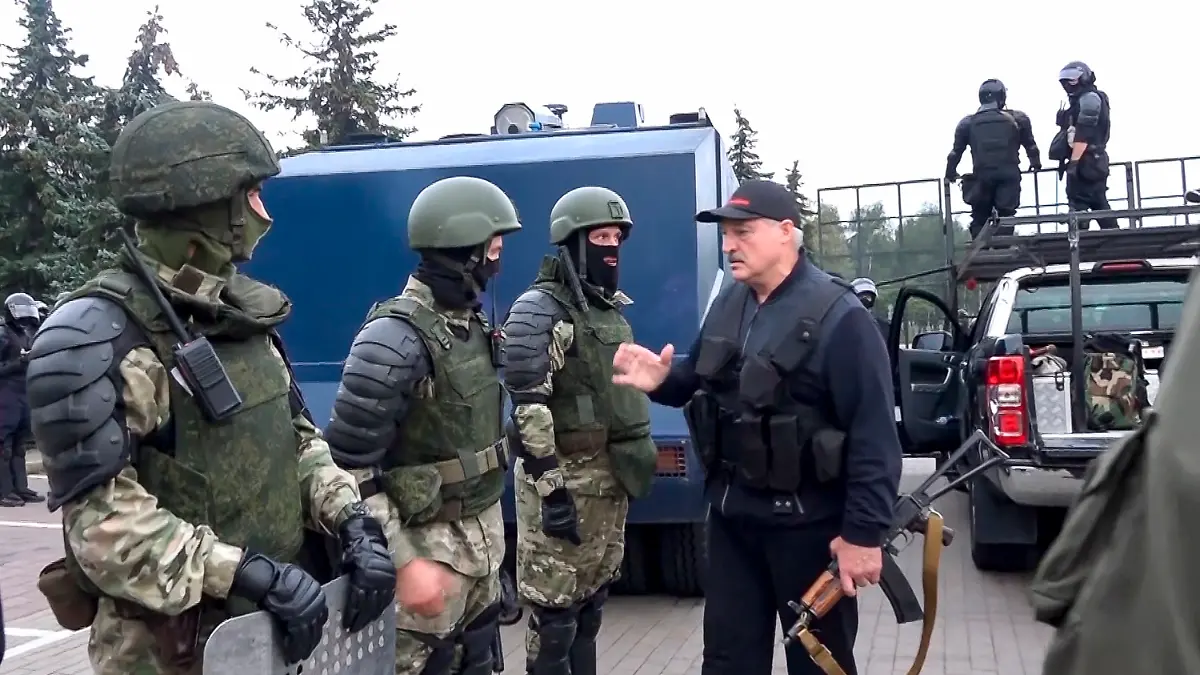 Machthaber Alexander Lukaschenko neben Sicherheitskräften.