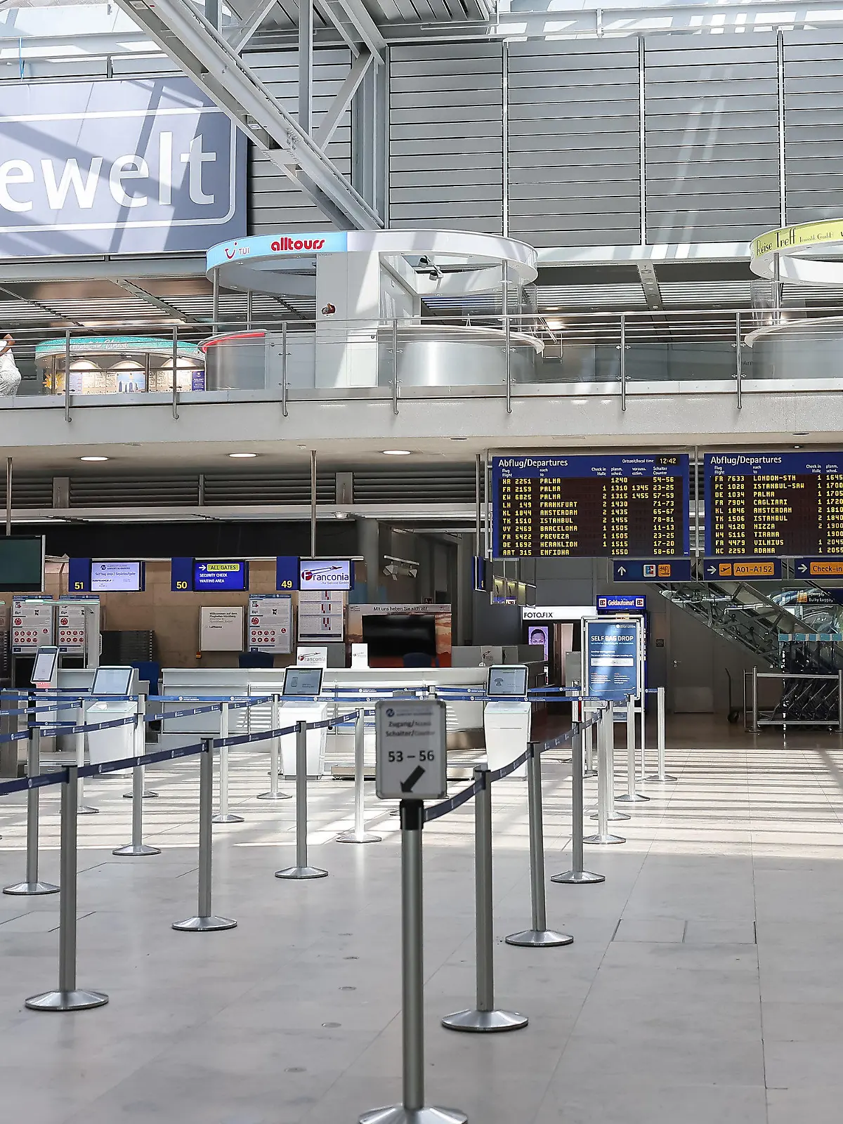 19.07.2024, Bayern, Nürnberg: Leere herrscht vor der automatisierten Gepäckaufnahme am Nürnberger Flughafen in der Abflughalle, das Anzeigendisplay am Nürnberger Flughafen zeigt zudem verspätete oder gestrichene Flüge an. Weltweite Probleme in den Computersystemen stören die An - und Abflüge bei Airlines am Nürnberger Flughafen. Foto: Daniel Löb/dpa +++ dpa-Bildfunk +++