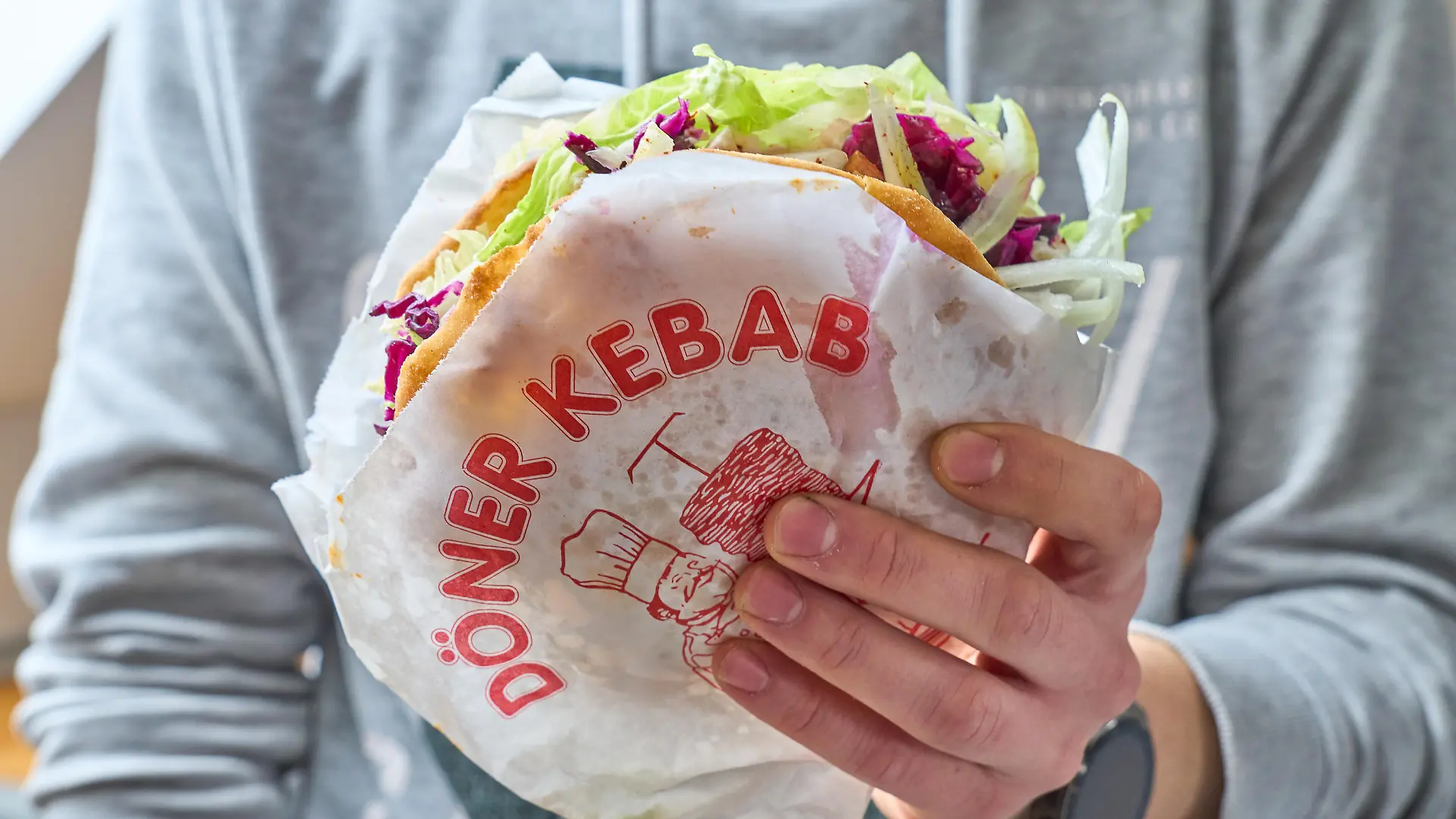 Mann hält einen türkischen Döner