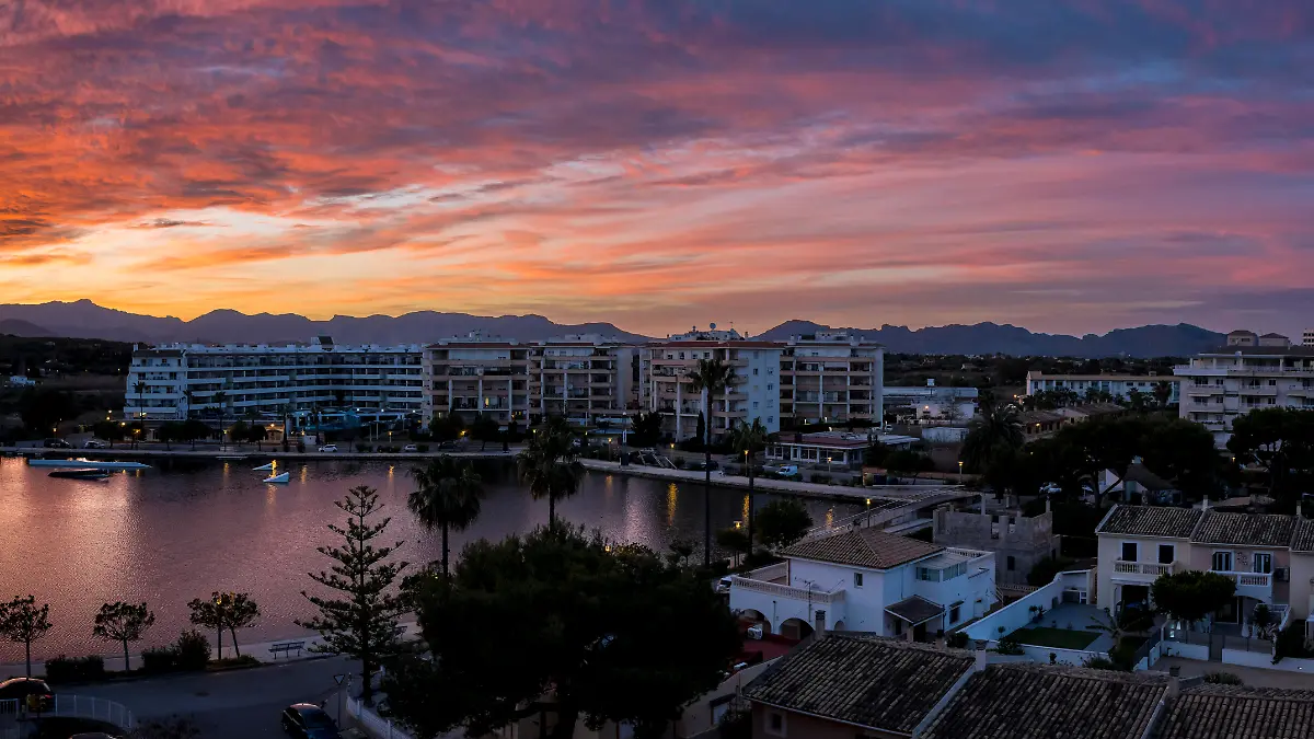 Die Sonner geht über dem Städtchen Port d’Alcúdia auf Mallorca unter.
