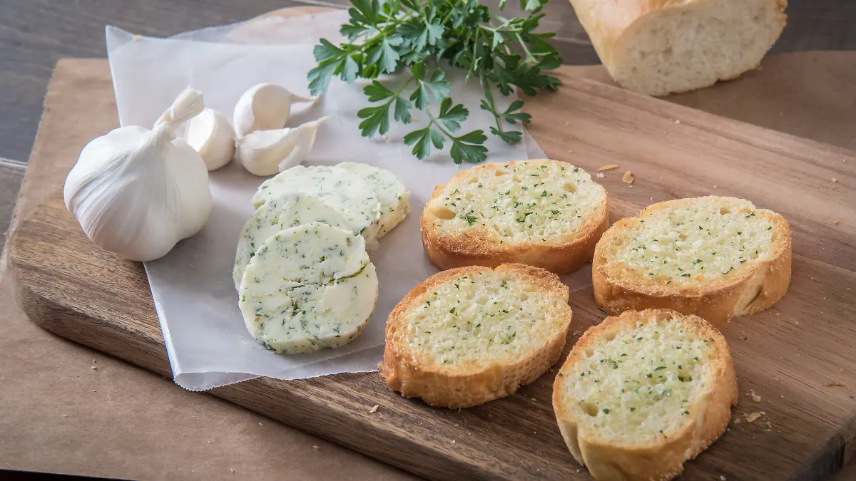 Knoblauch und Knoblauchbutter auf Baguette in Küche.