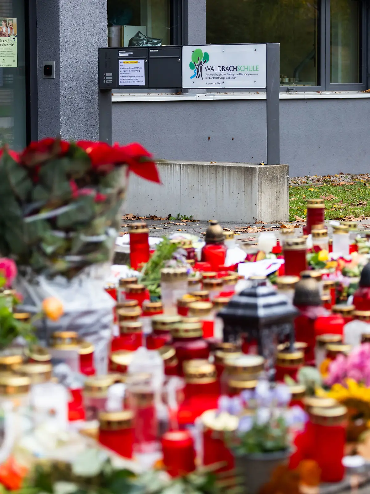 ARCHIV - 14.11.2023, Baden-Württemberg, Offenburg: Kerzen und Blumen liegen vor dem Eingang der Waldbachschule. (zu dpa: «Attacke auf Schüler - Urteil im Mordprozess erwartet») Foto: Philipp von Ditfurth/dpa +++ dpa-Bildfunk +++