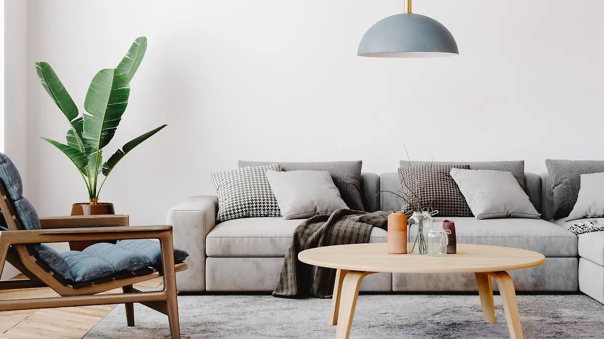 Modern living room setup with classic parquet floor. Furnished with light gray sofa, blue arm chair with wooden frame, modern blue ceiling lamp, wooden coffee table and gray carpet.