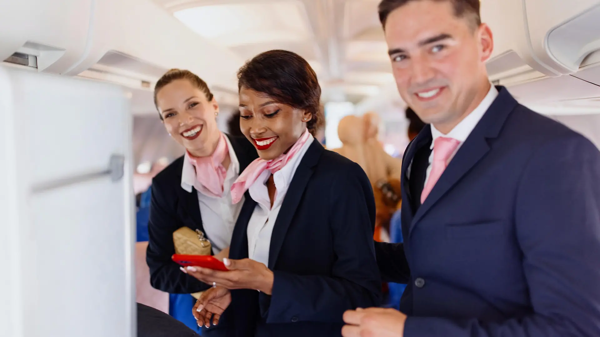 Smiling flight attendants looking at camera during disembarking