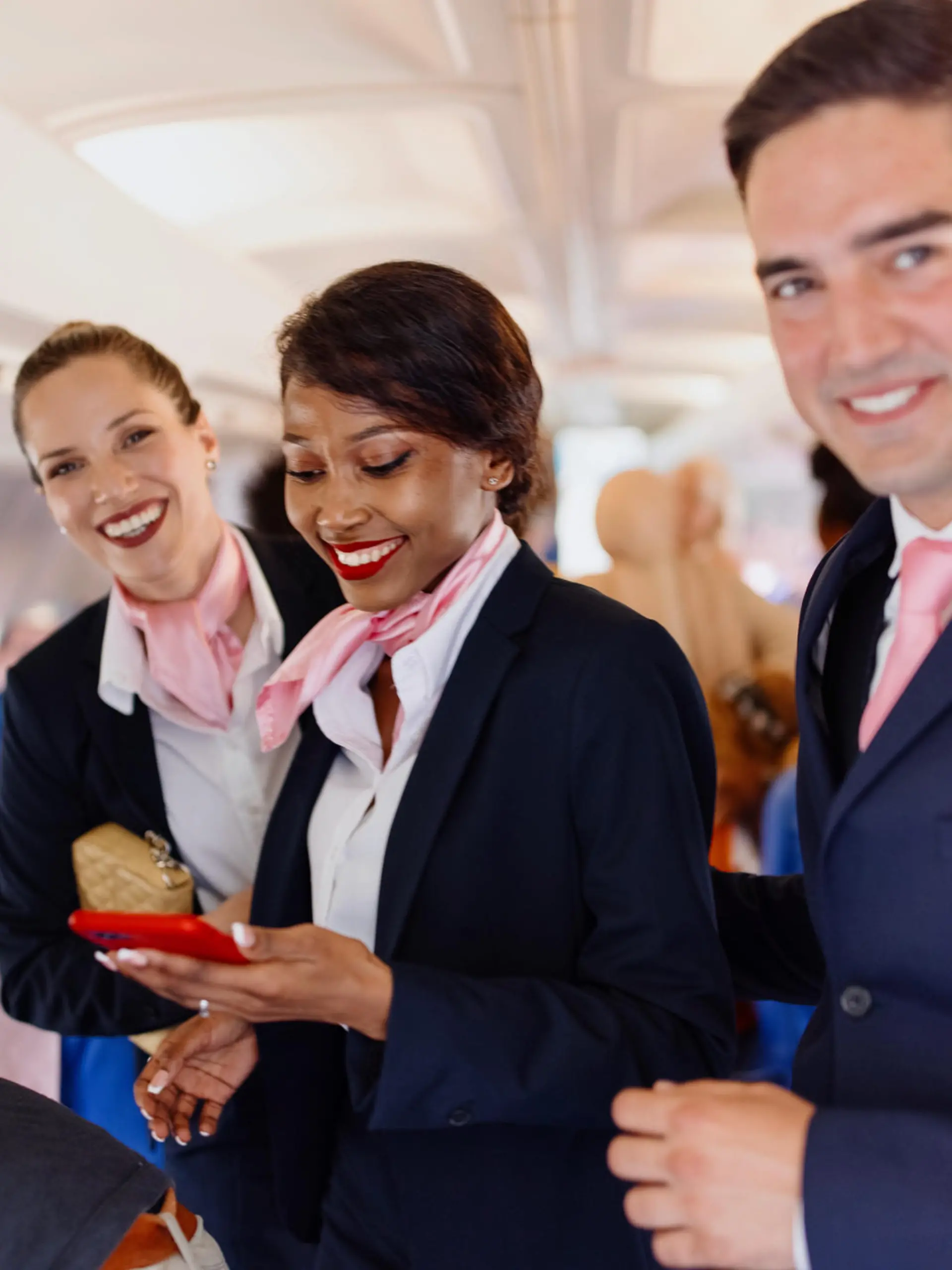 Smiling flight attendants looking at camera during disembarking