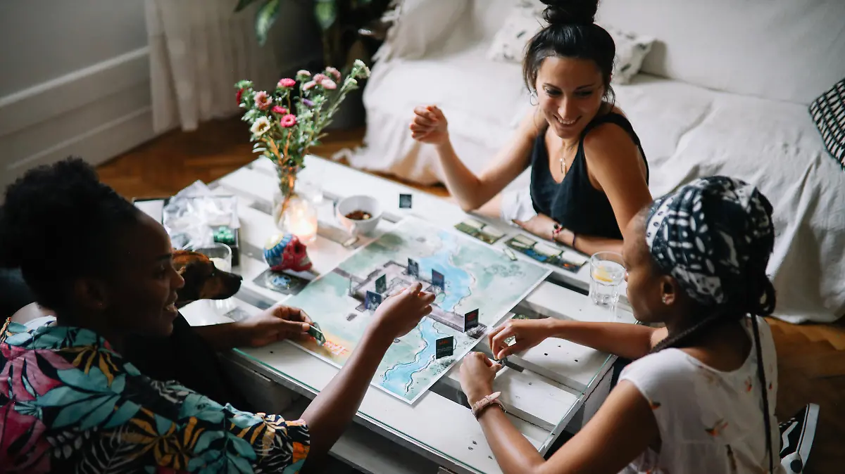 Group of friends spending an easy afternoon, playing a role playing style boardgames at their home. Wizards and skeletons making their fate through the throwing dice.