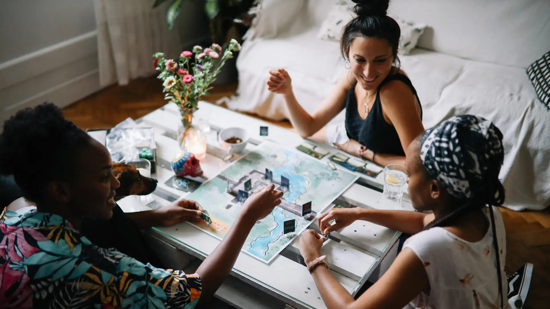 Group of friends spending an easy afternoon, playing a role playing style boardgames at their home. Wizards and skeletons making their fate through the throwing dice.