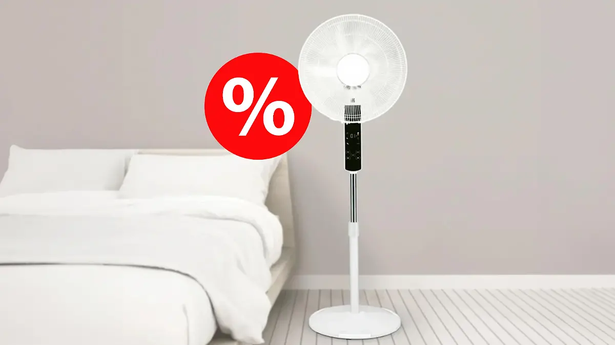 Der Silvercrest Standventilator in einem dunkelbeige gestrichenem Zimmer neben einem Bett und einem rot-weißen Prozentzeichen an der Seite.